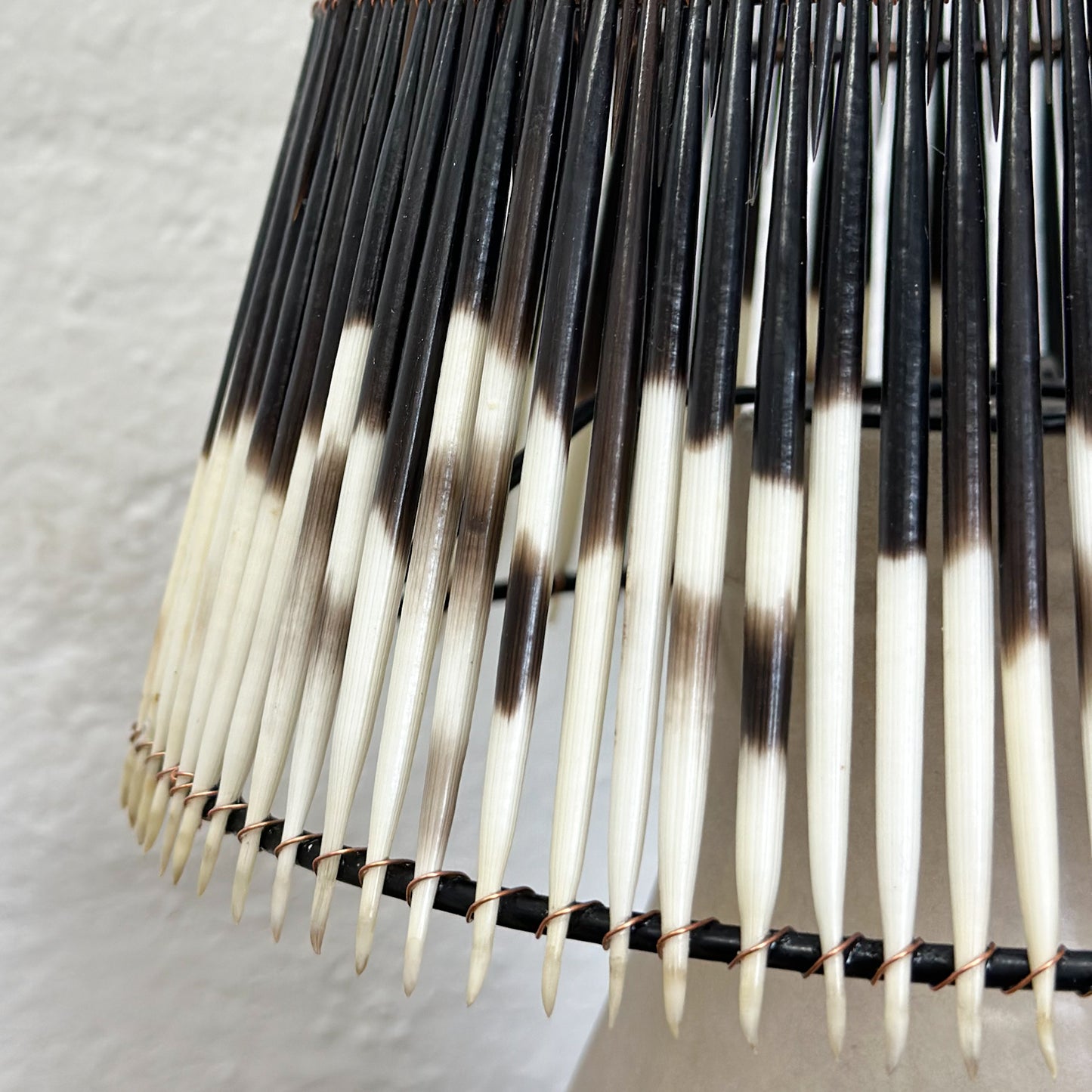 A lampshade with a geometric pattern of black and white quills.