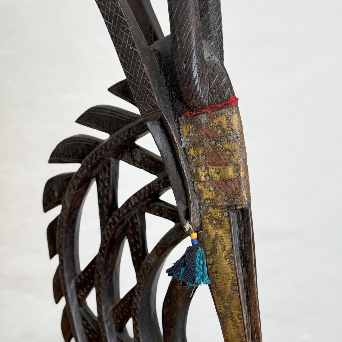 A sculpture of a mythical creature with a metal structure having a mix of dark and light brown colors, standing upright against a plain background.