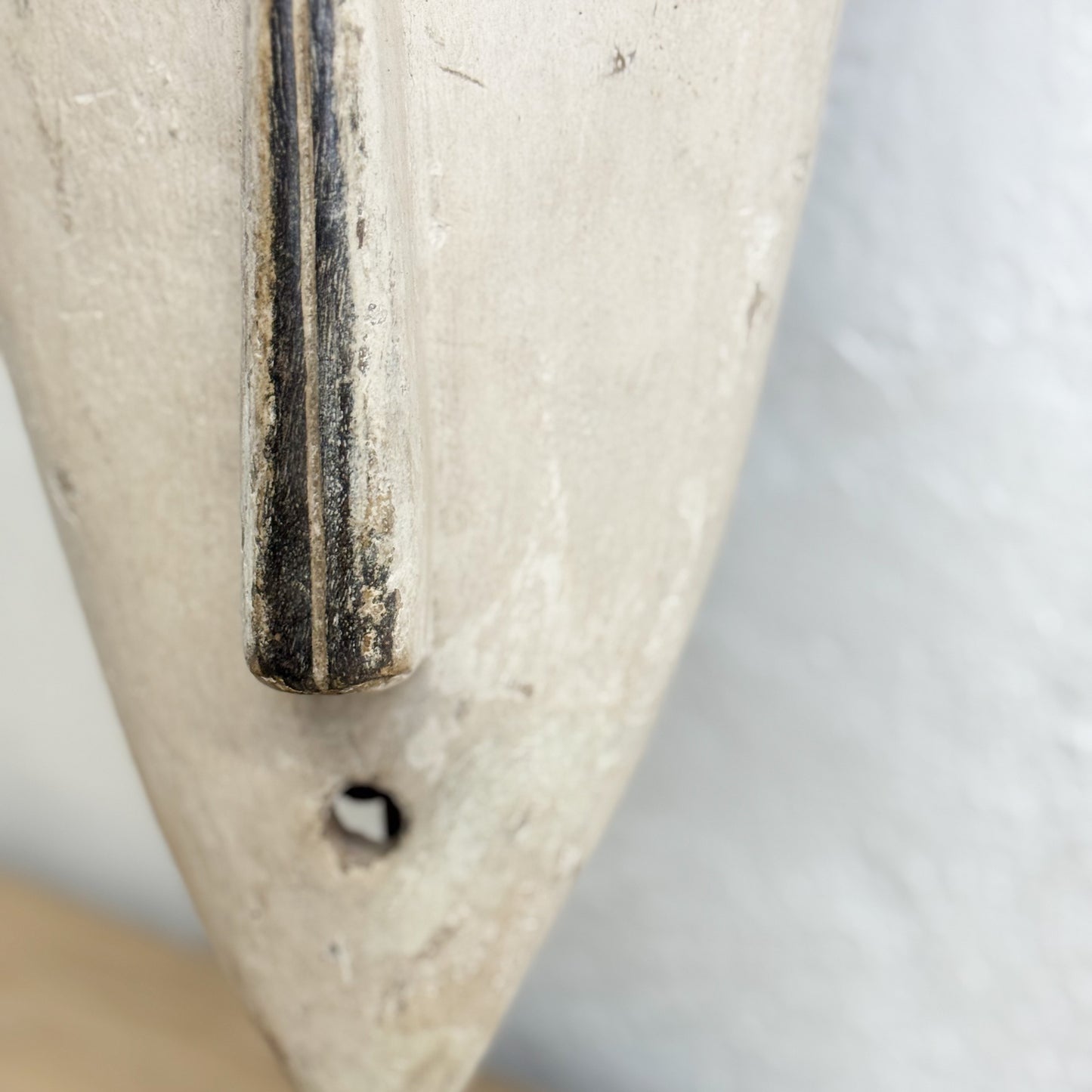 Close-up of a metallic object with a textured surface on a light gray background