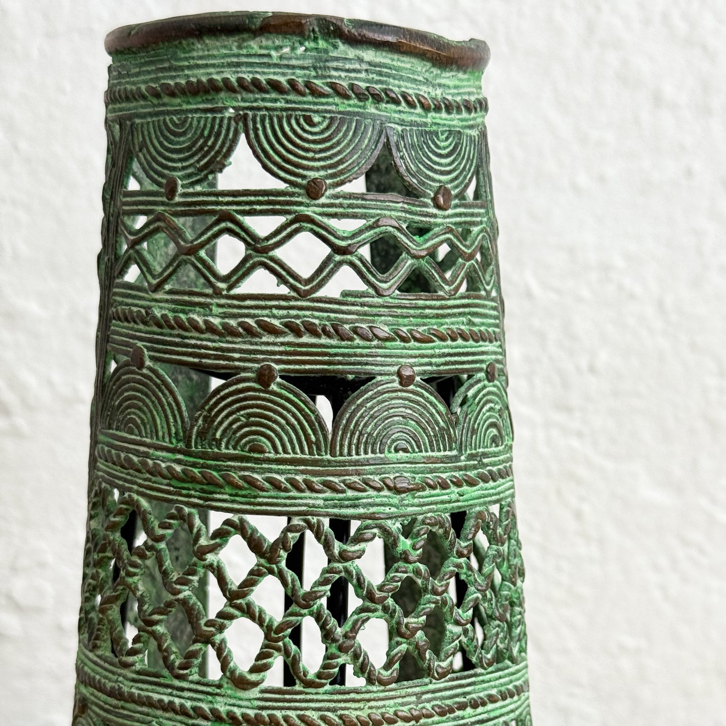 Decorative green ceramic lantern with intricate patterns on a white background
