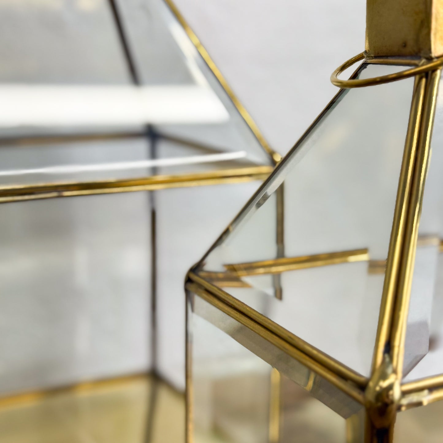 Gold-framed glass display case with a blurred background