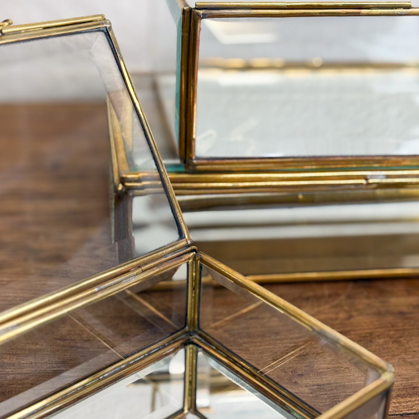 Set of glass boxes with gold frames on a wooden surface