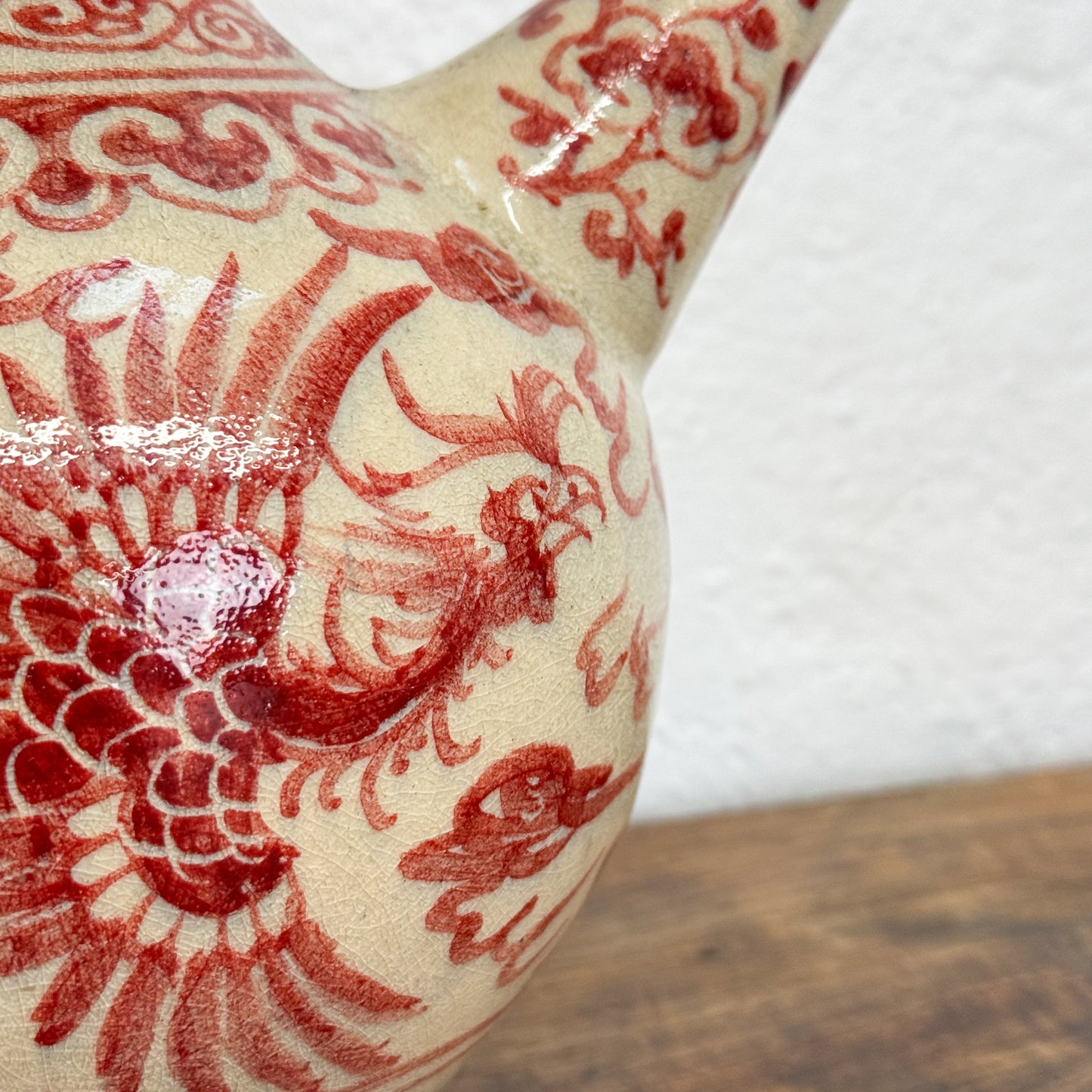 Ceramic teapot with red dragon design on a white background