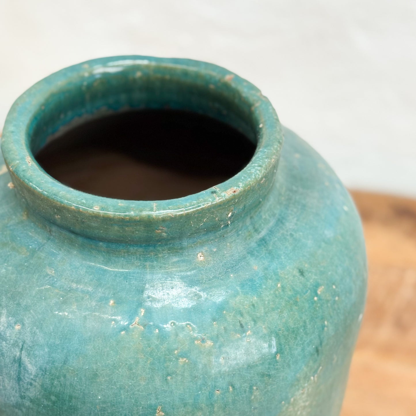 Close-up of a textured blue ceramic jar on a neutral background