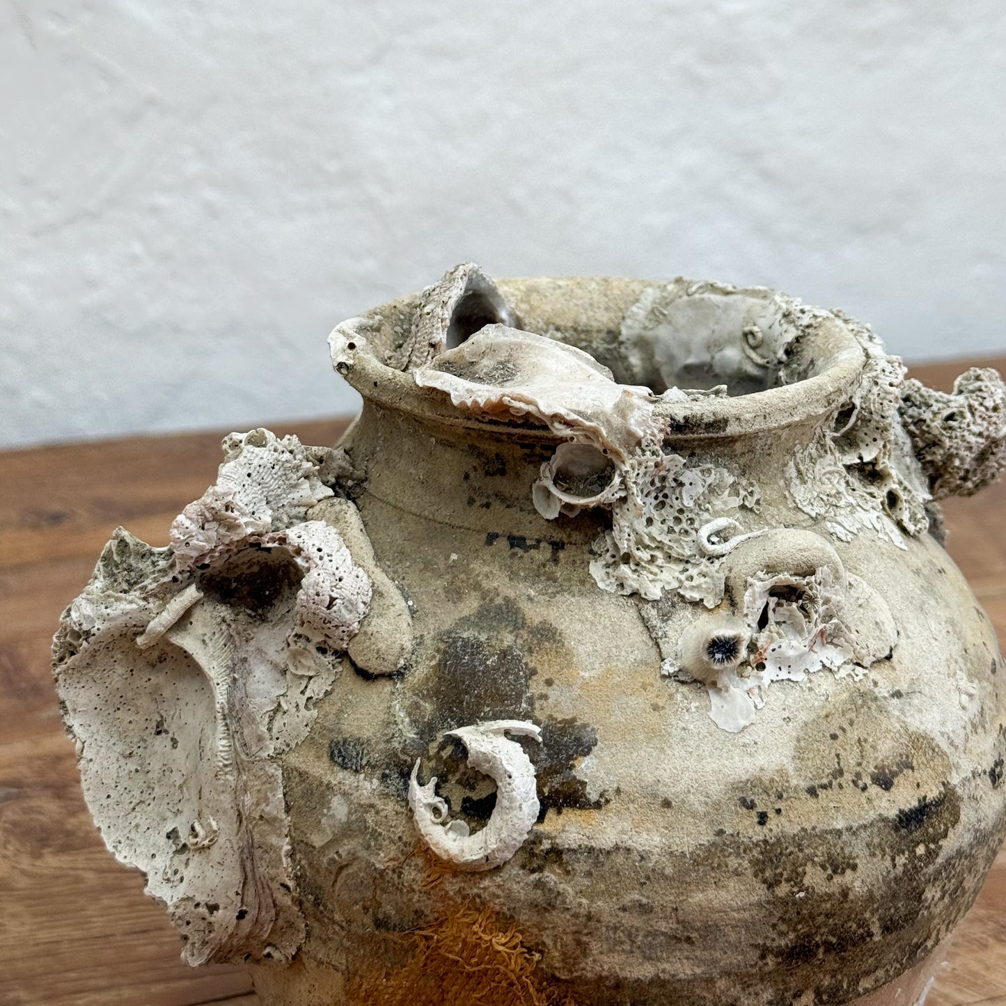 Decorative ceramic vase with textured surface on a wooden surface