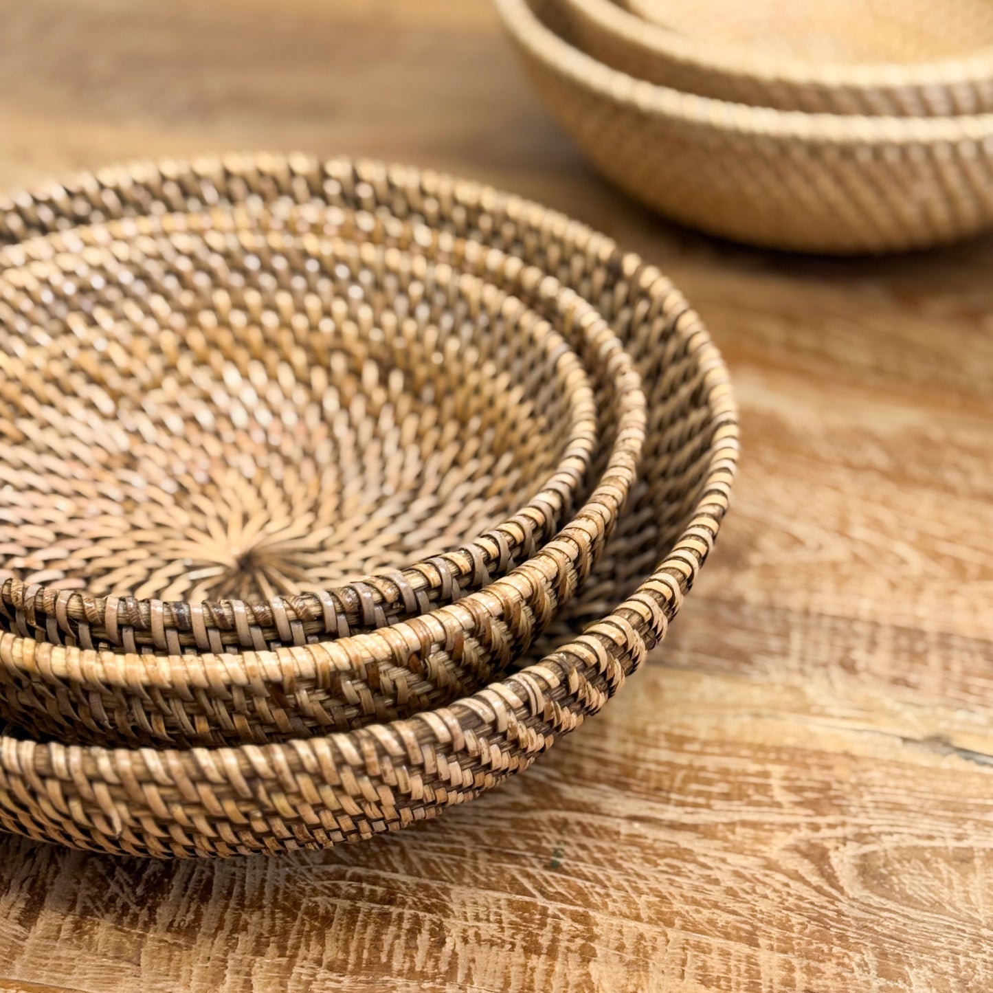 Stack of woven baskets on a wooden surface
