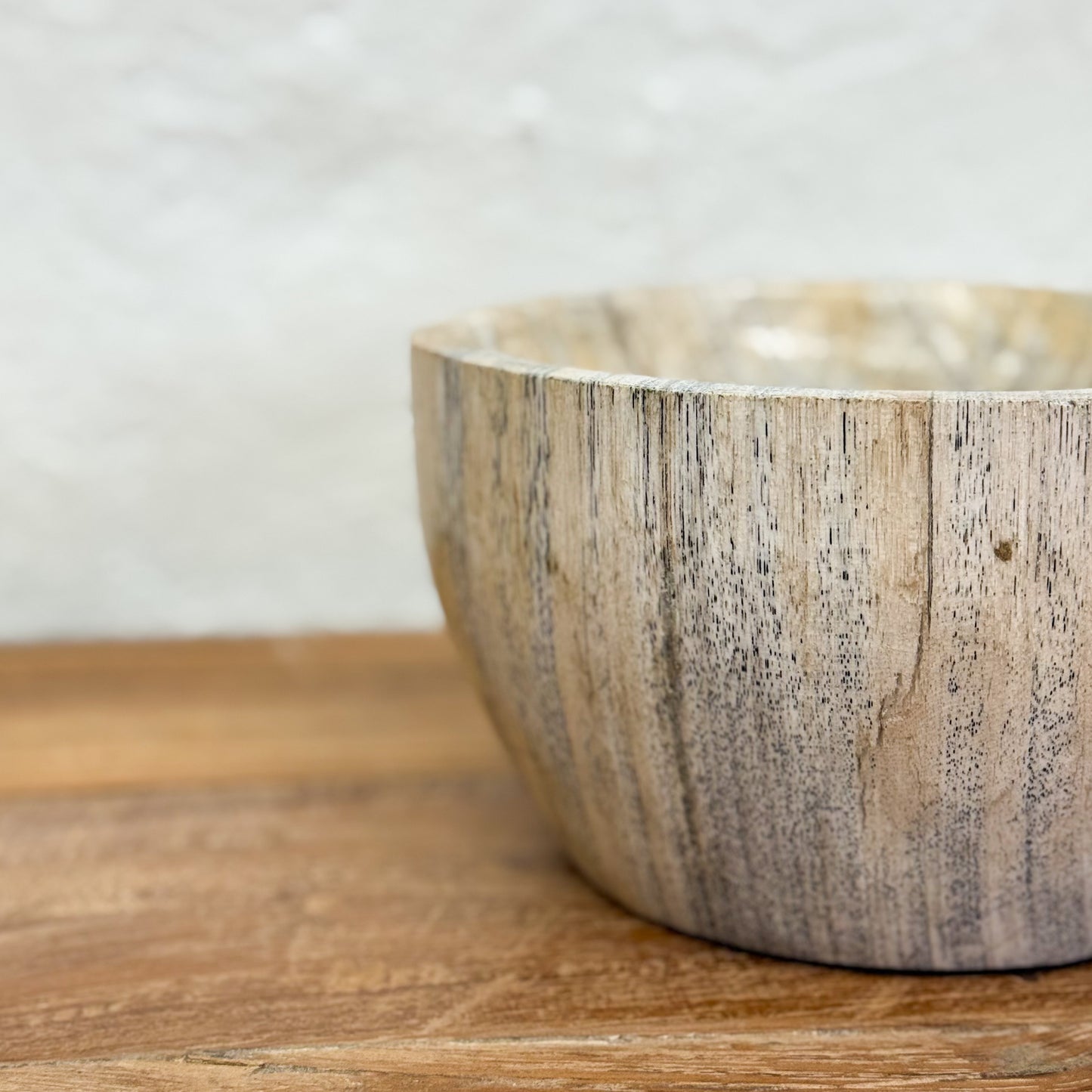 Wooden bowl with a natural grain pattern on a wooden surface