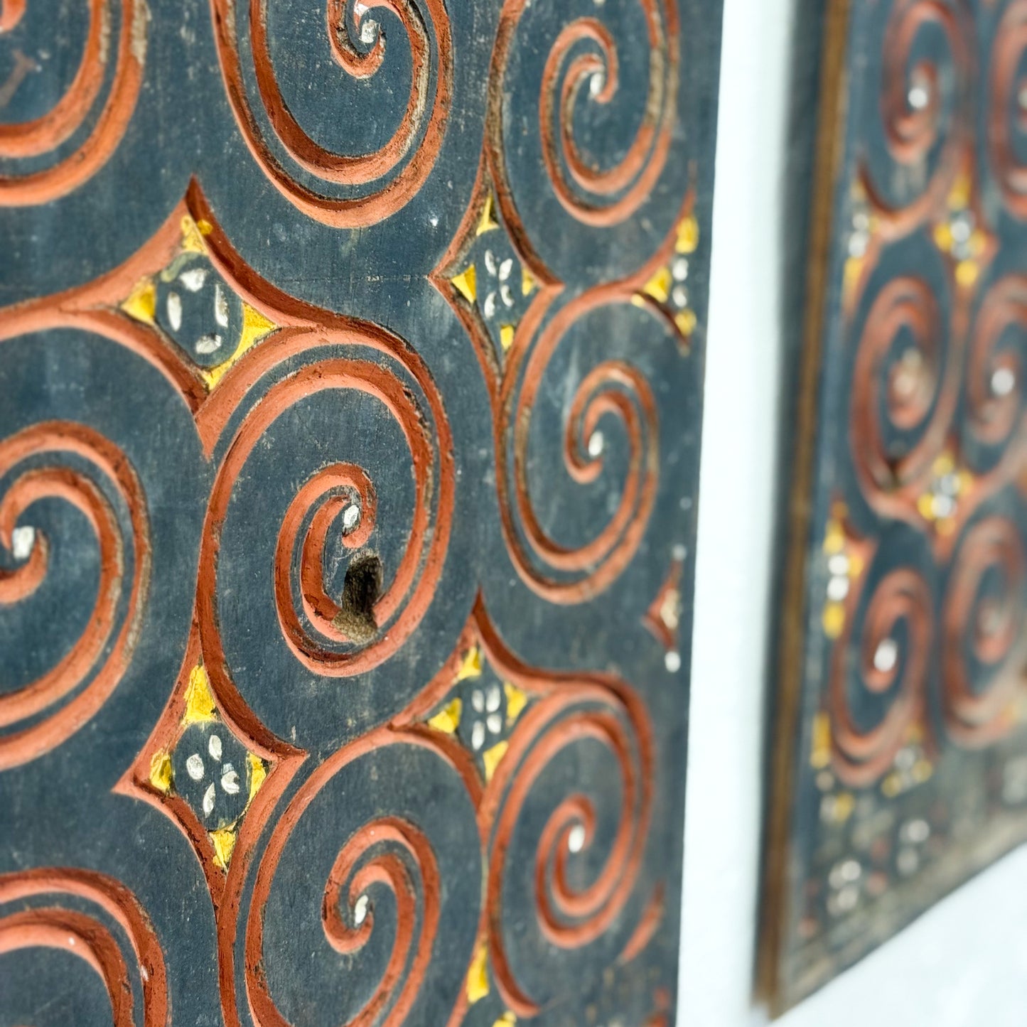Decorative metal panel with swirling patterns on a white background