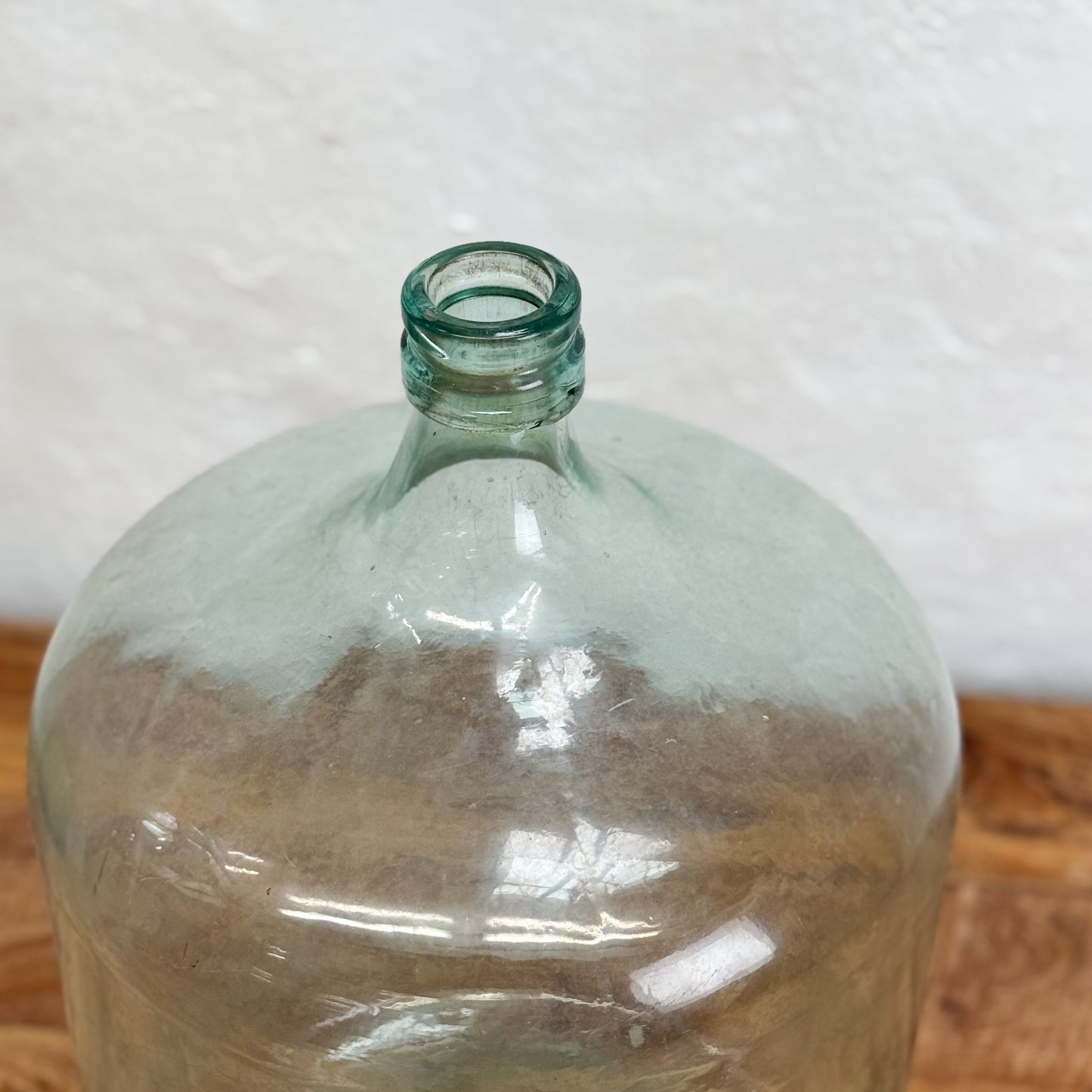 Clear glass bottle on a wooden surface with a white background