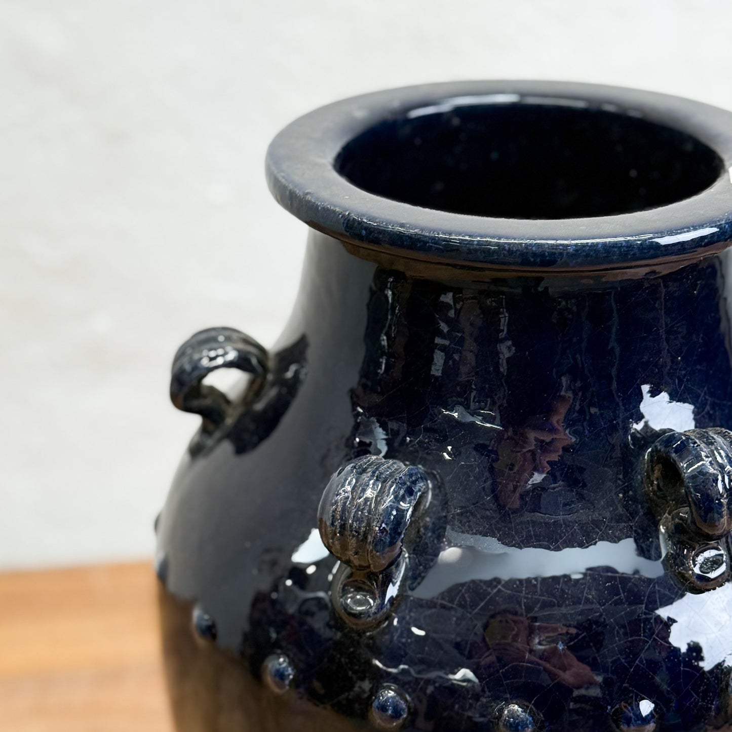 Blue ceramic vase with textured surface on a wooden surface