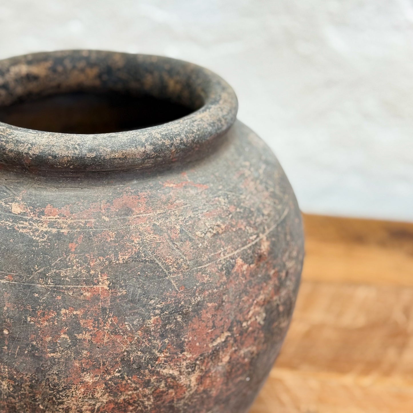 Vintage terracotta pot on a wooden surface with a white background