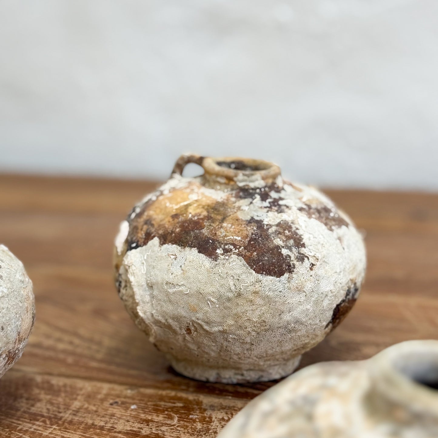 Antique ceramic jar with a rustic finish on a wooden surface