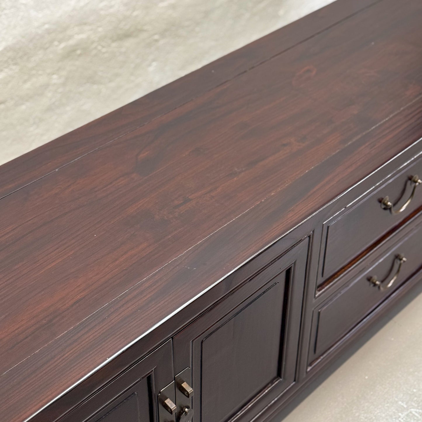 A vintage style low cabinet with 2 drawers and 4 doors, featuring wooden handles and a dark wood finish.