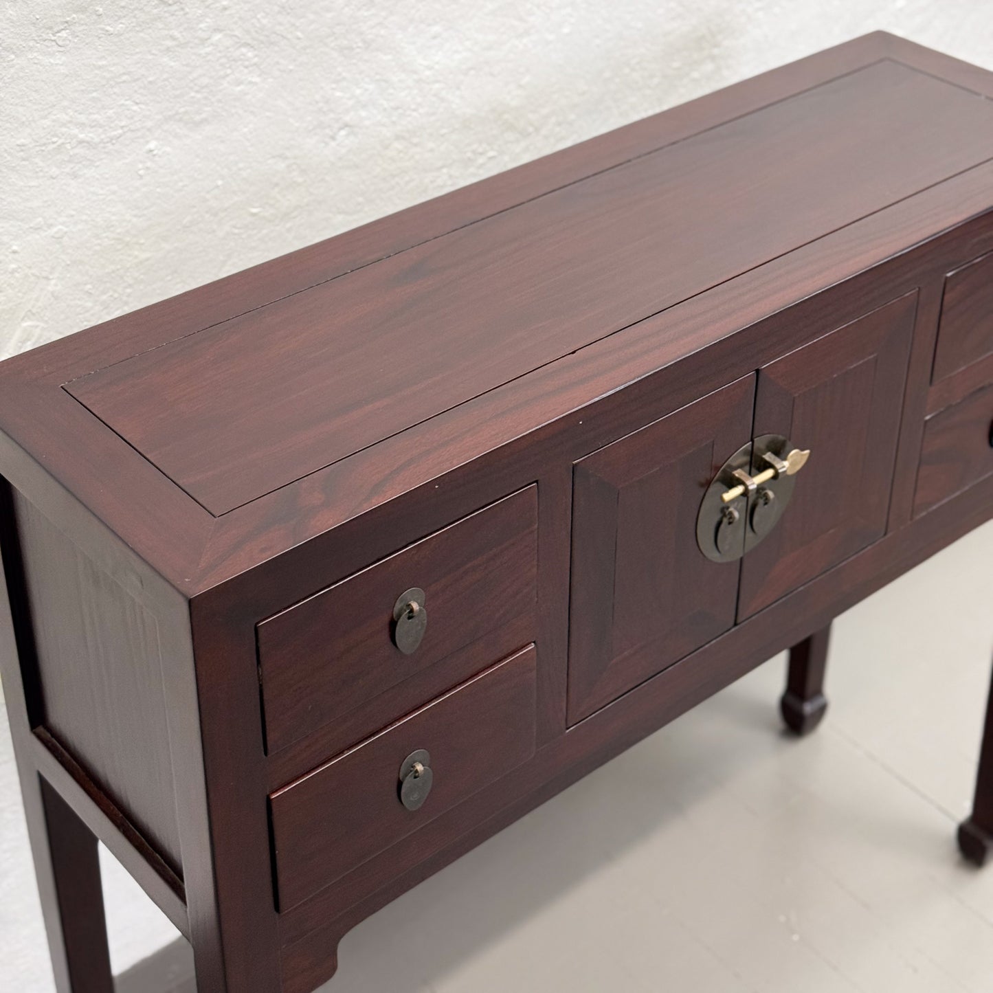 A brown wooden console table with multiple drawers and a decorative knob on the top drawer, placed against a white background.