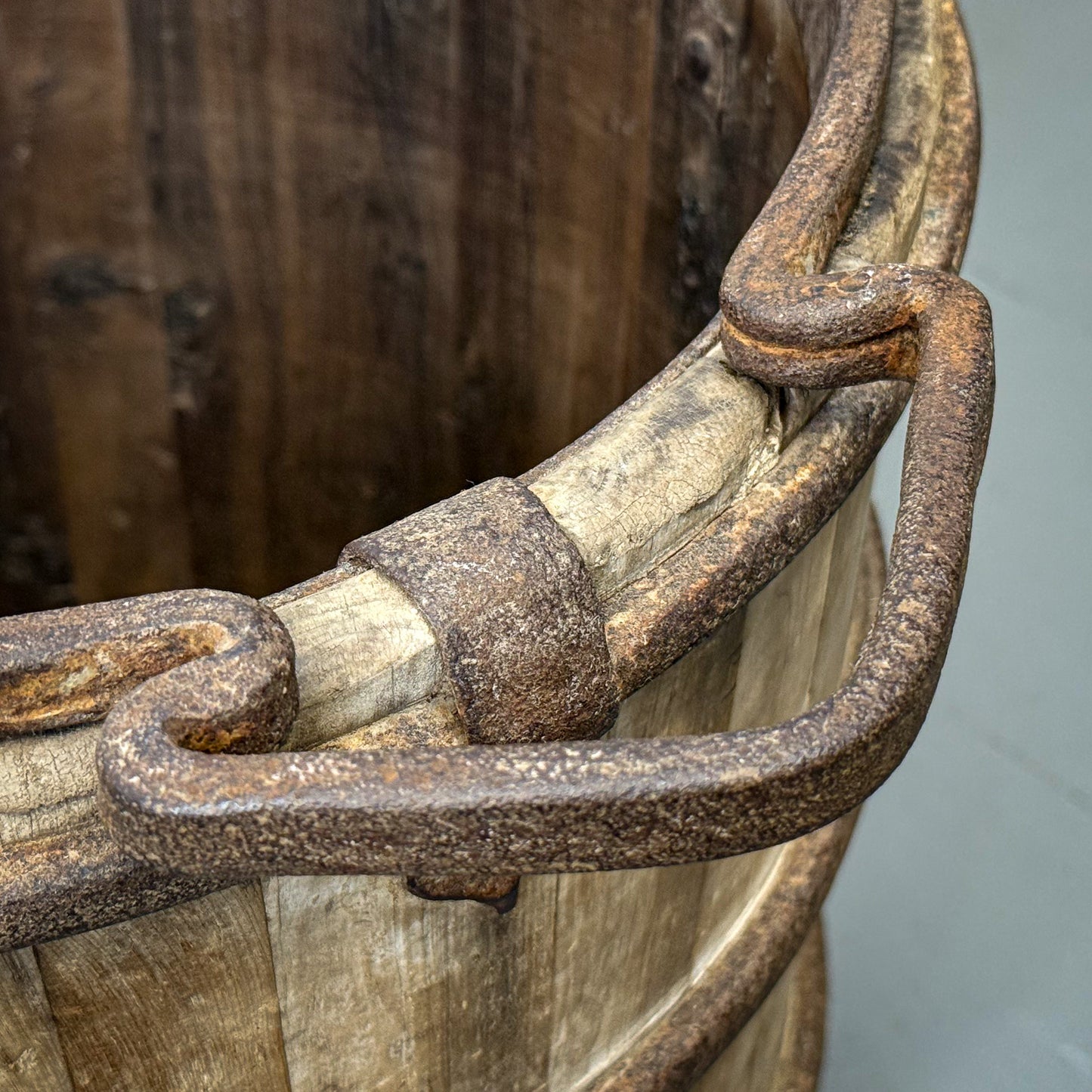 Rusticated metal handle on a wooden barrel with a neutral background