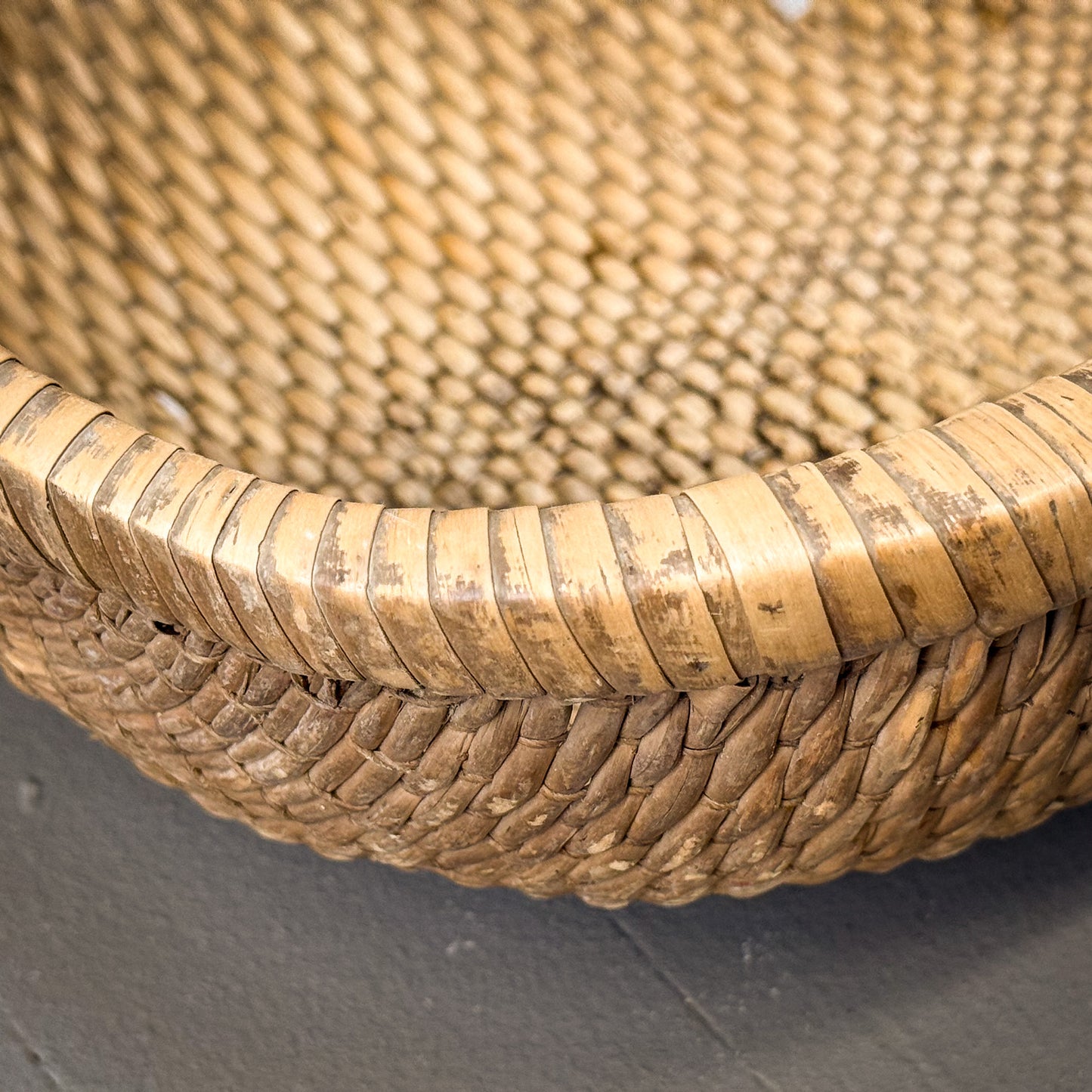 Close-up of a woven basket with a textured surface on a gray background