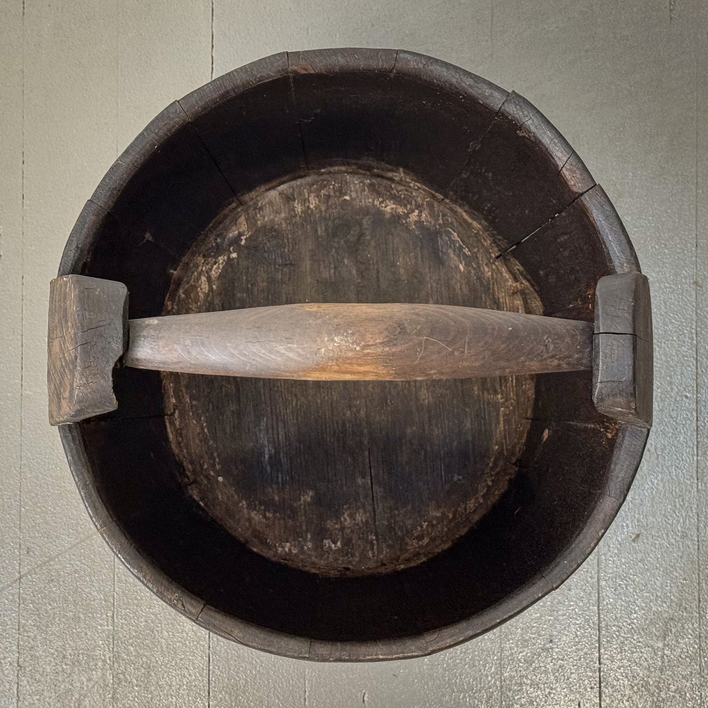 Wooden bucket with a handle on a textured surface