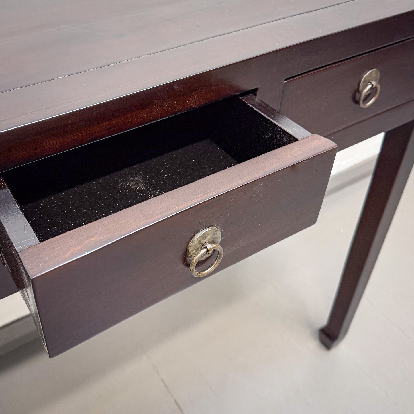 Wooden desk with an open drawer on a light background