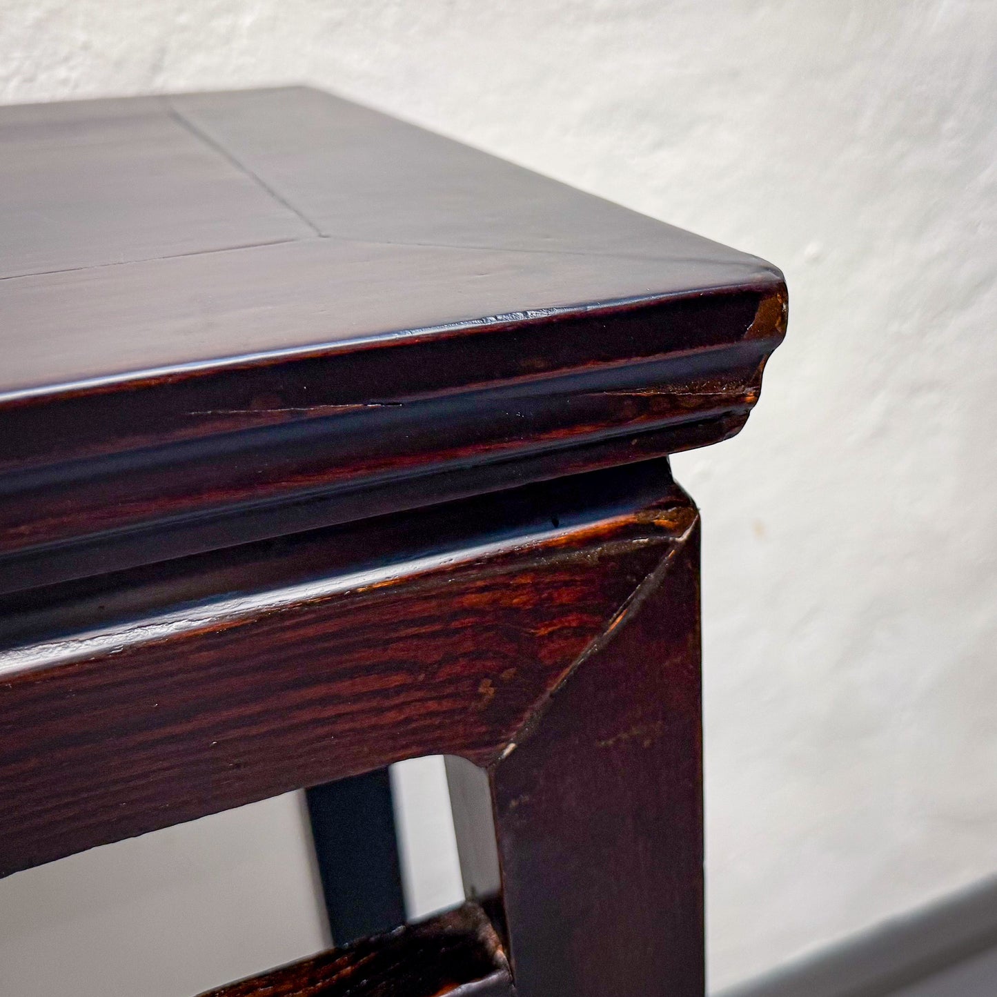 Close-up of a wooden table corner with a white background