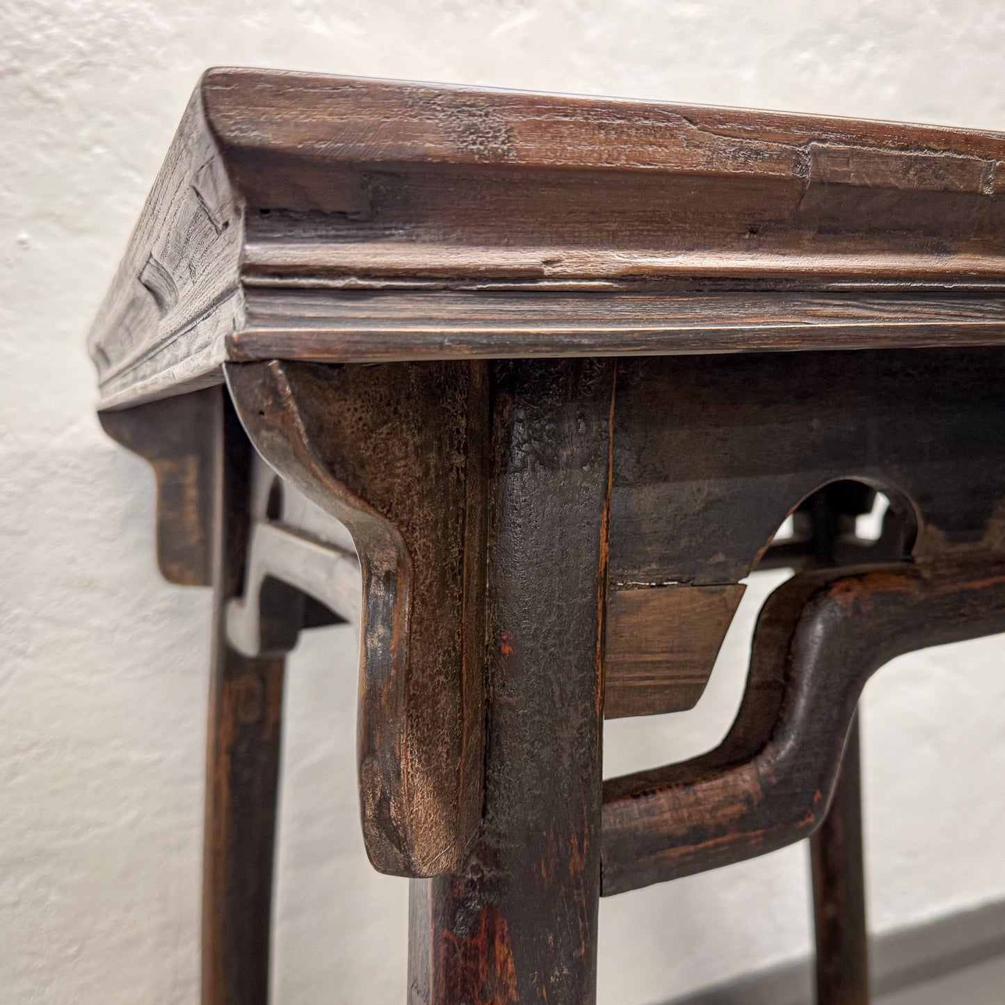 Close-up of a wooden table with intricate carvings on a light background