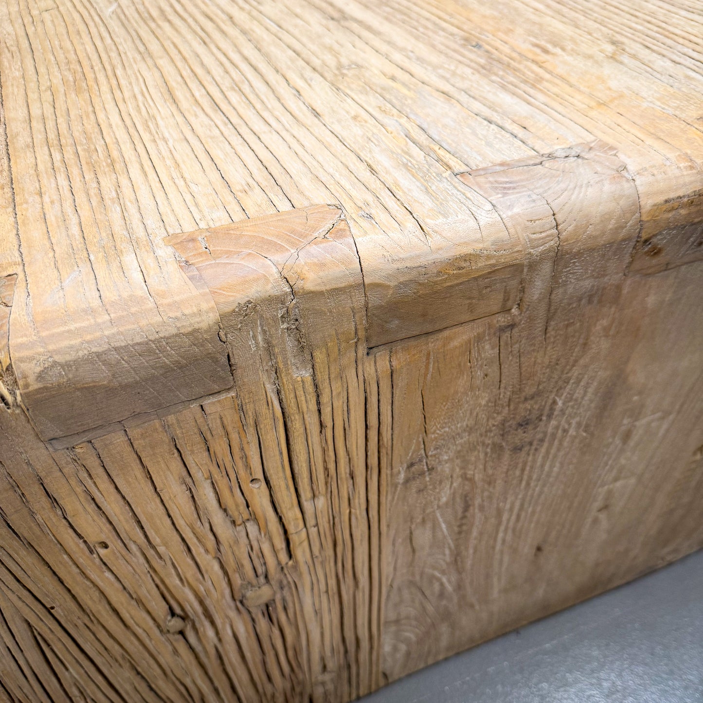 Close-up of a wooden bench with a natural, rustic finish.