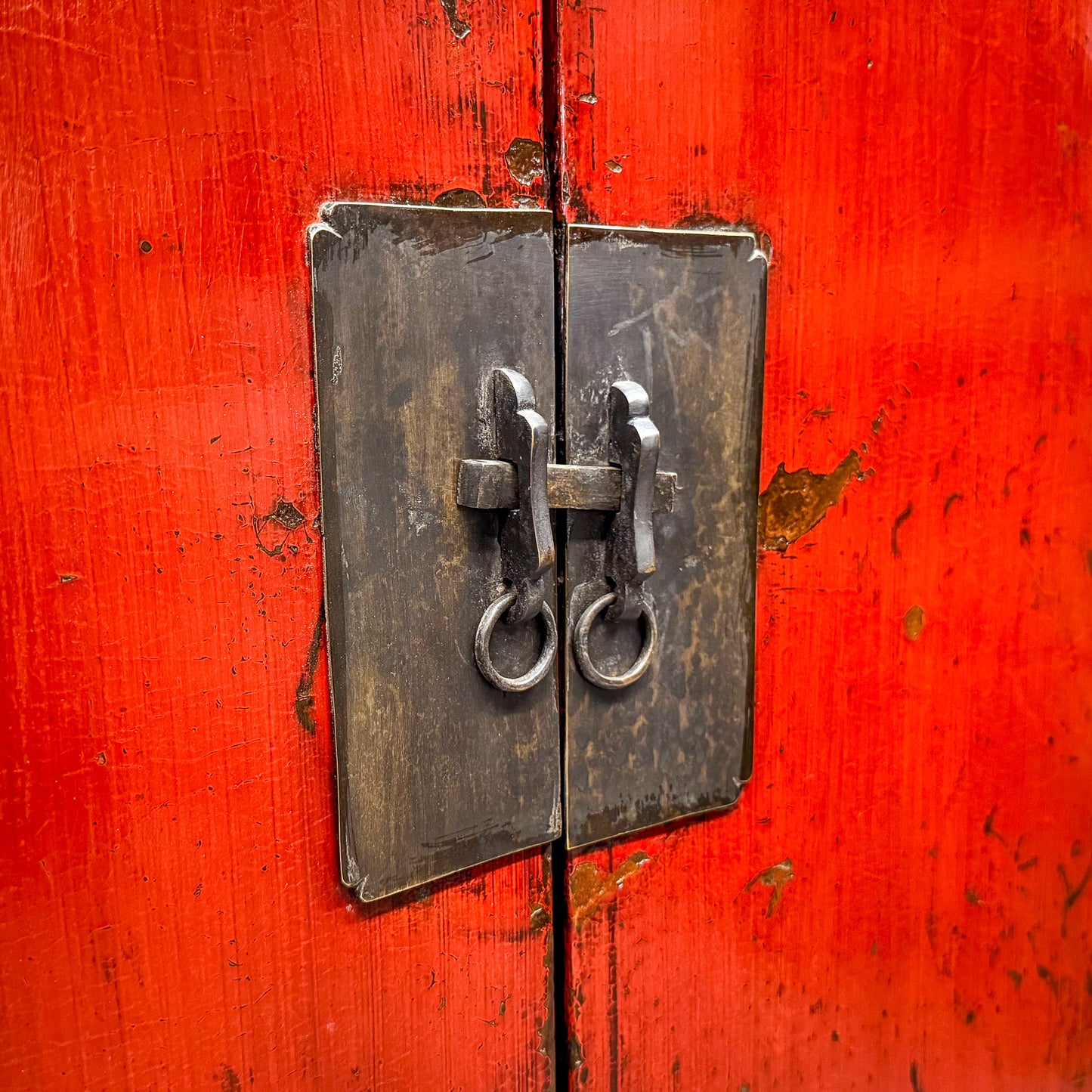 Close-up of a red wooden door with a metal lock
