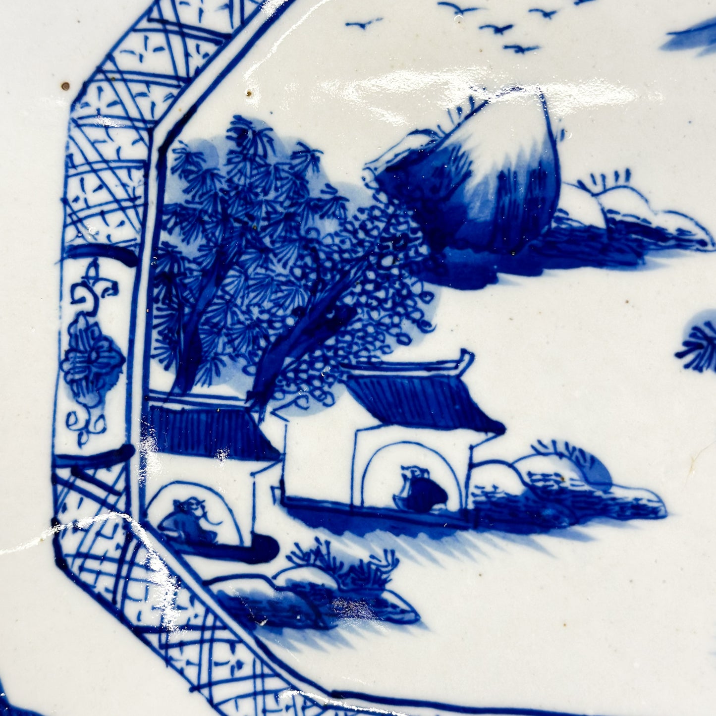 Octagonal porcelain platter with a traditional cobalt blue color, depicting a village scene with mountain, trees, and huts motifs.