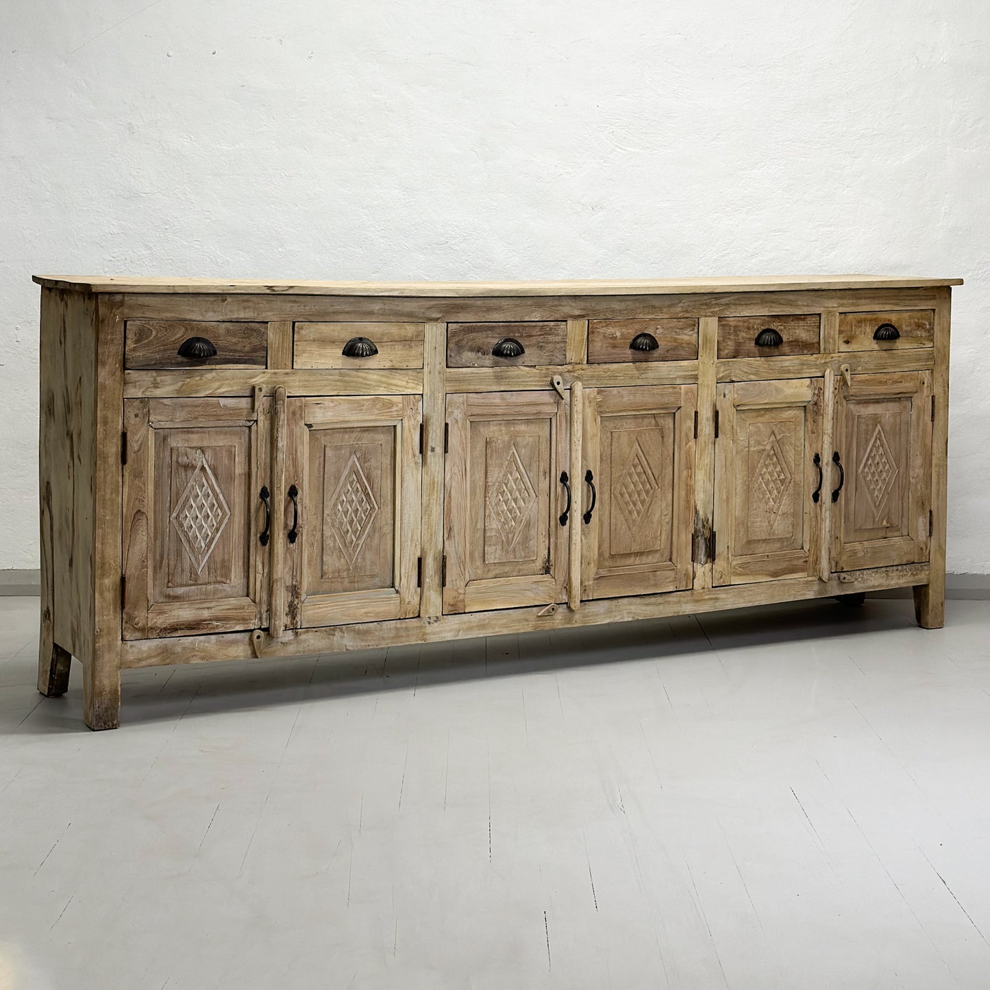 A bleached vintage 6-door panelled sideboard with geometric design details and ironwork hinges.