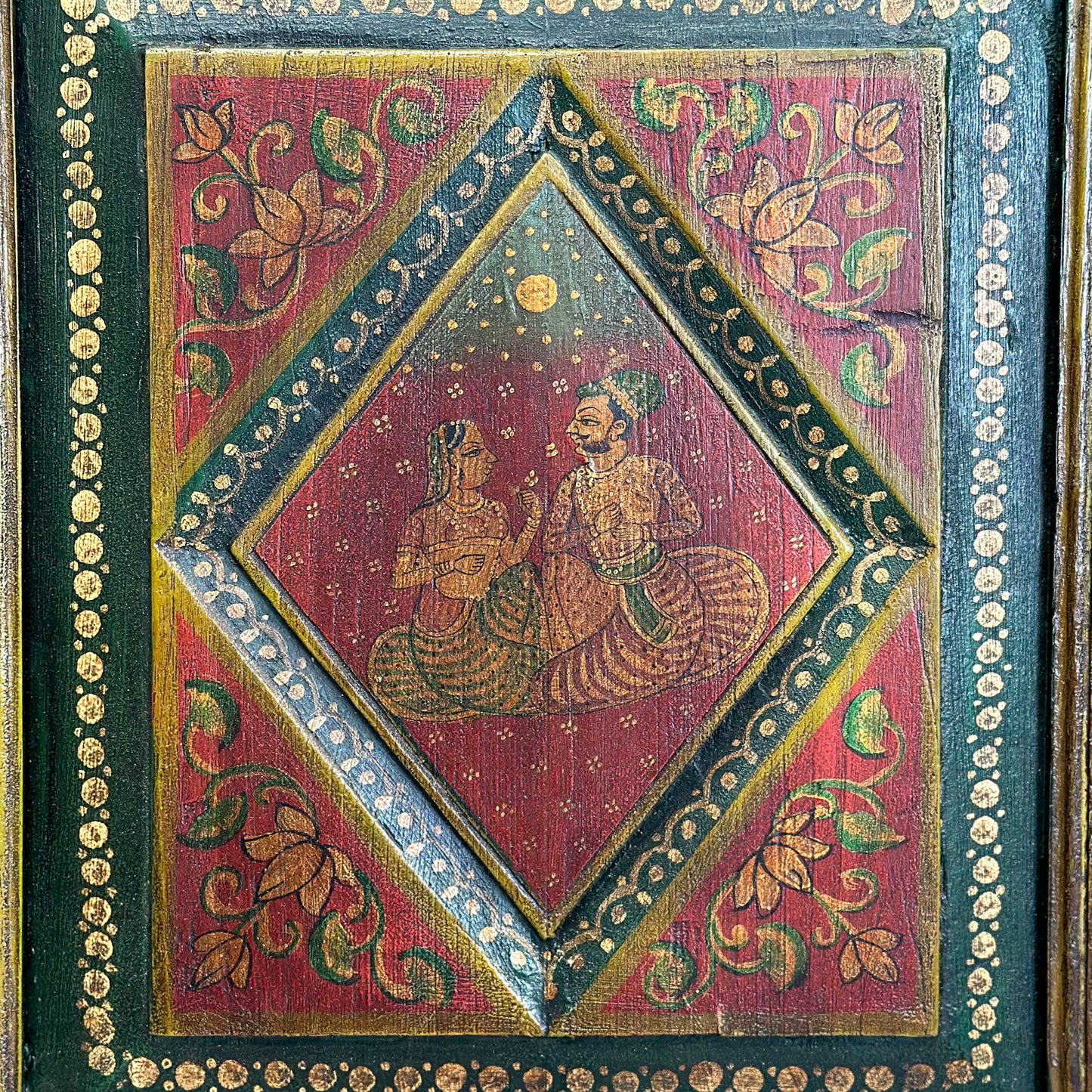 A pair of hand-painted Rajasthan doors featuring floral motifs and story panels with a rich red color palette and gold detailing.