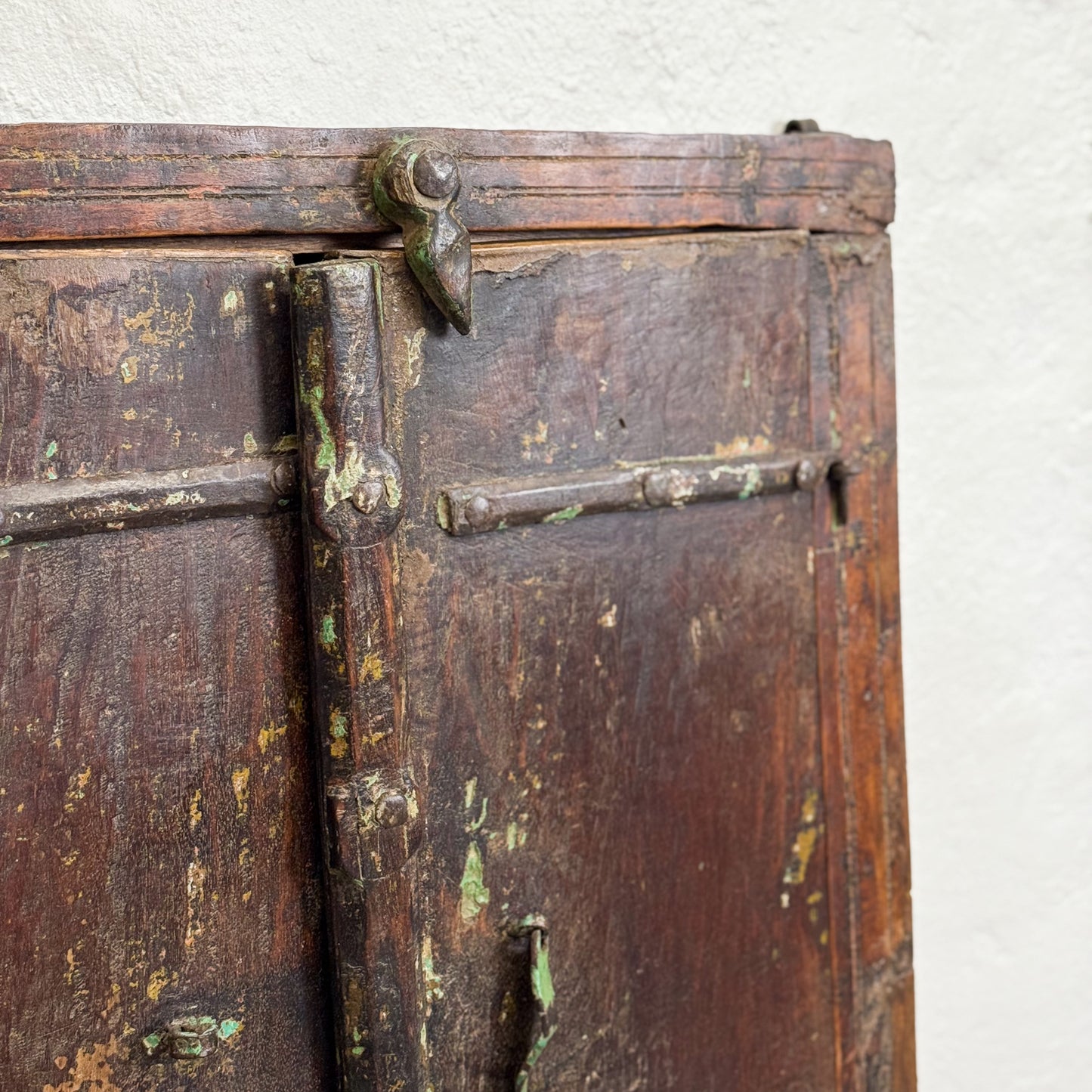 Close-up of an old wooden door with a metal latch on a white background