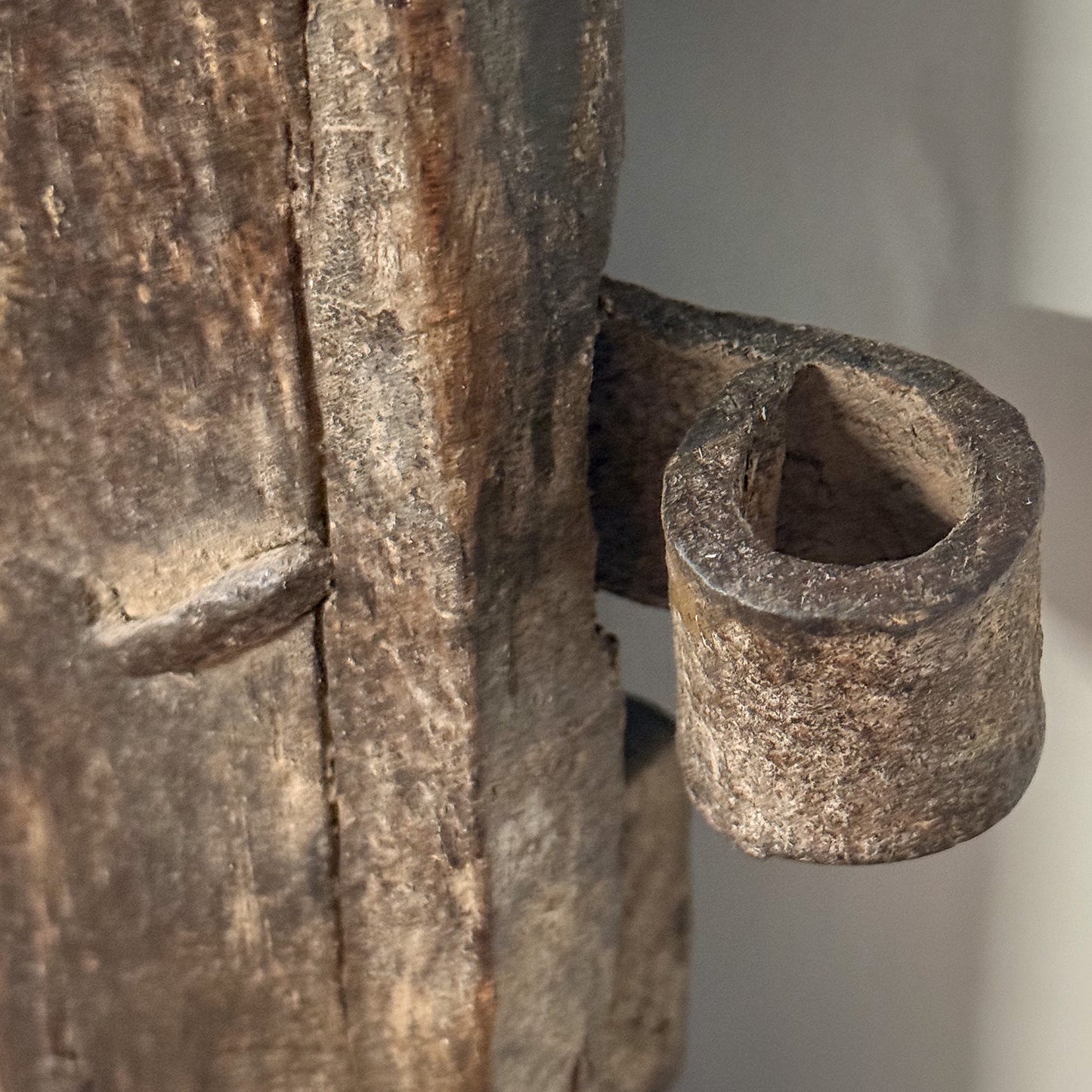 Close-up of a rustic wooden object with a cylindrical hole.