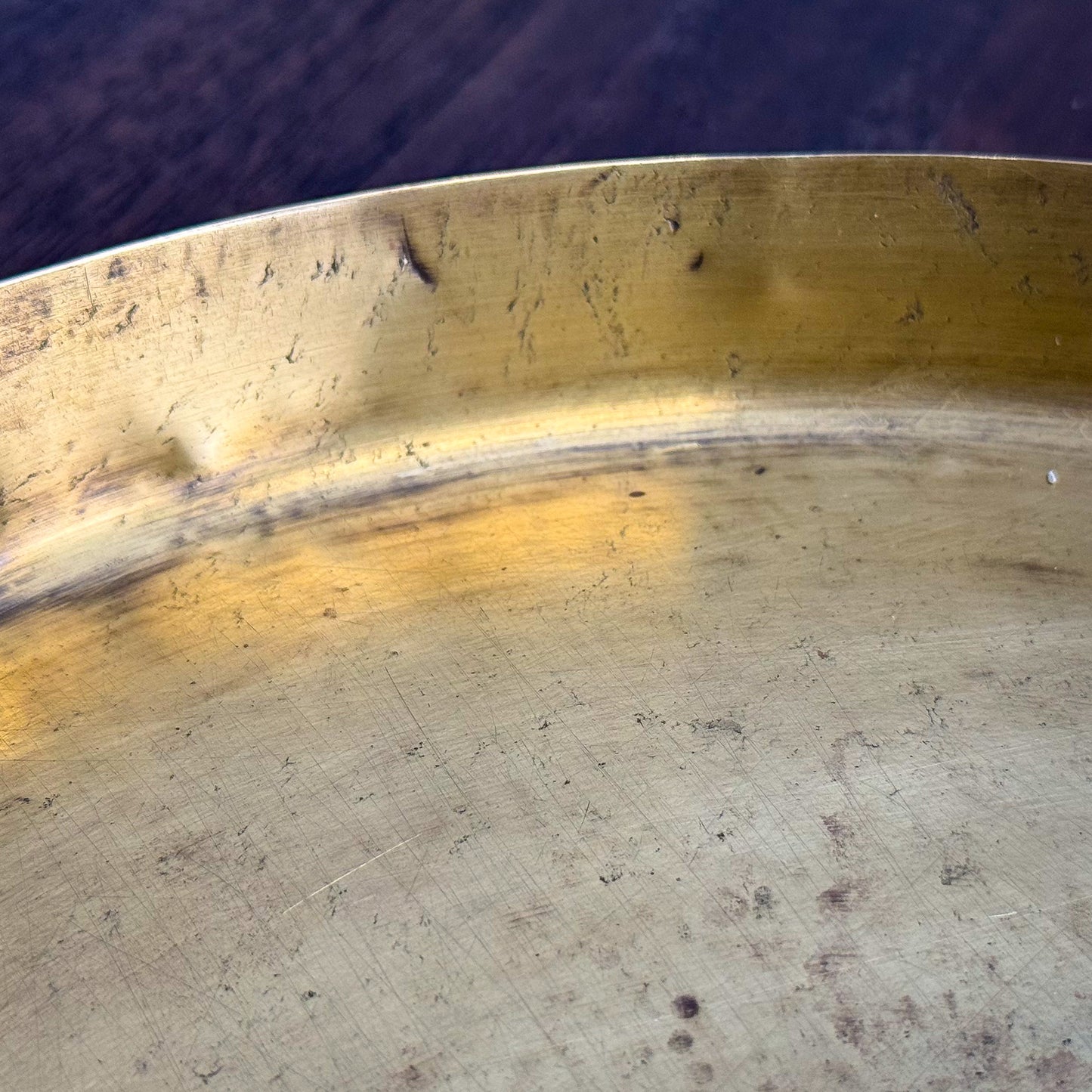 Close-up of a worn metal surface with visible scratches and discoloration.