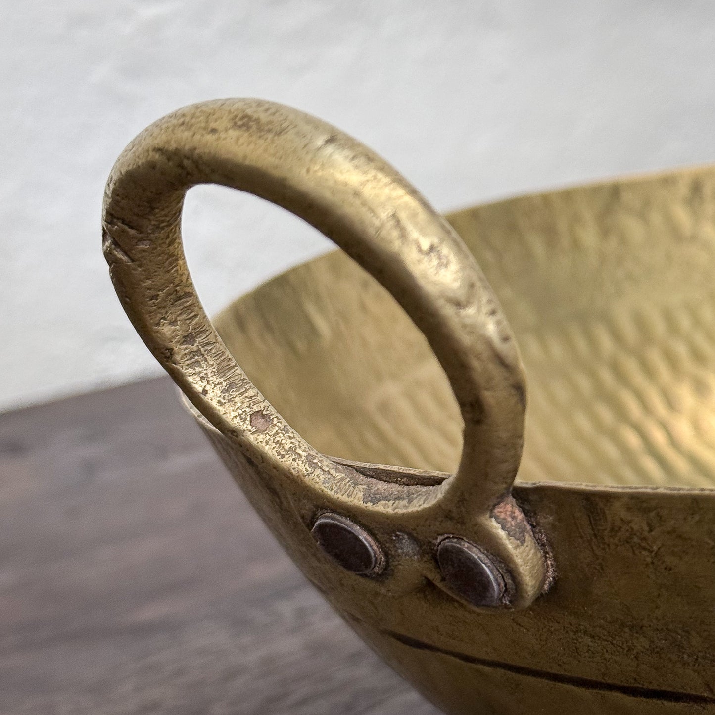 Close-up of a textured yellow ceramic bowl with a handle on a neutral background