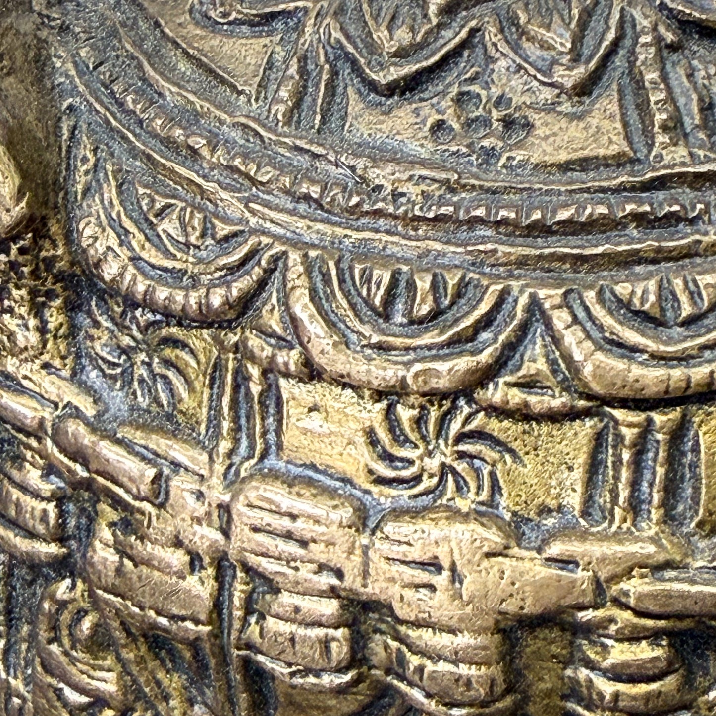 Close-up of intricate bronze or gold decorative element with detailed patterns