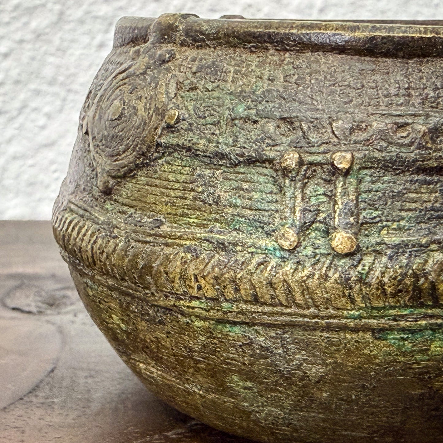 Close-up of a textured ceramic bowl with decorative patterns on a wooden surface.
