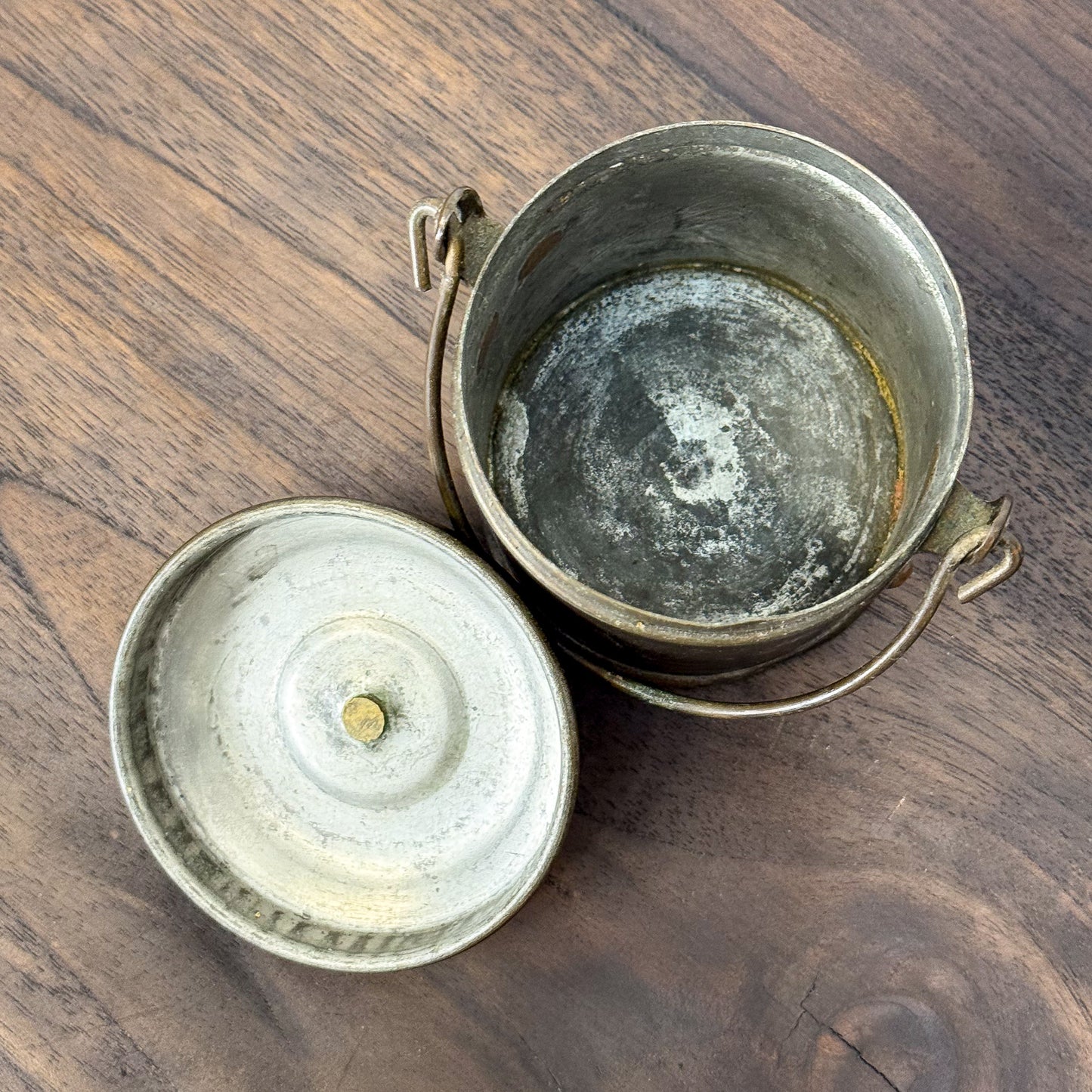 Two vintage-style metal containers on a wooden surface