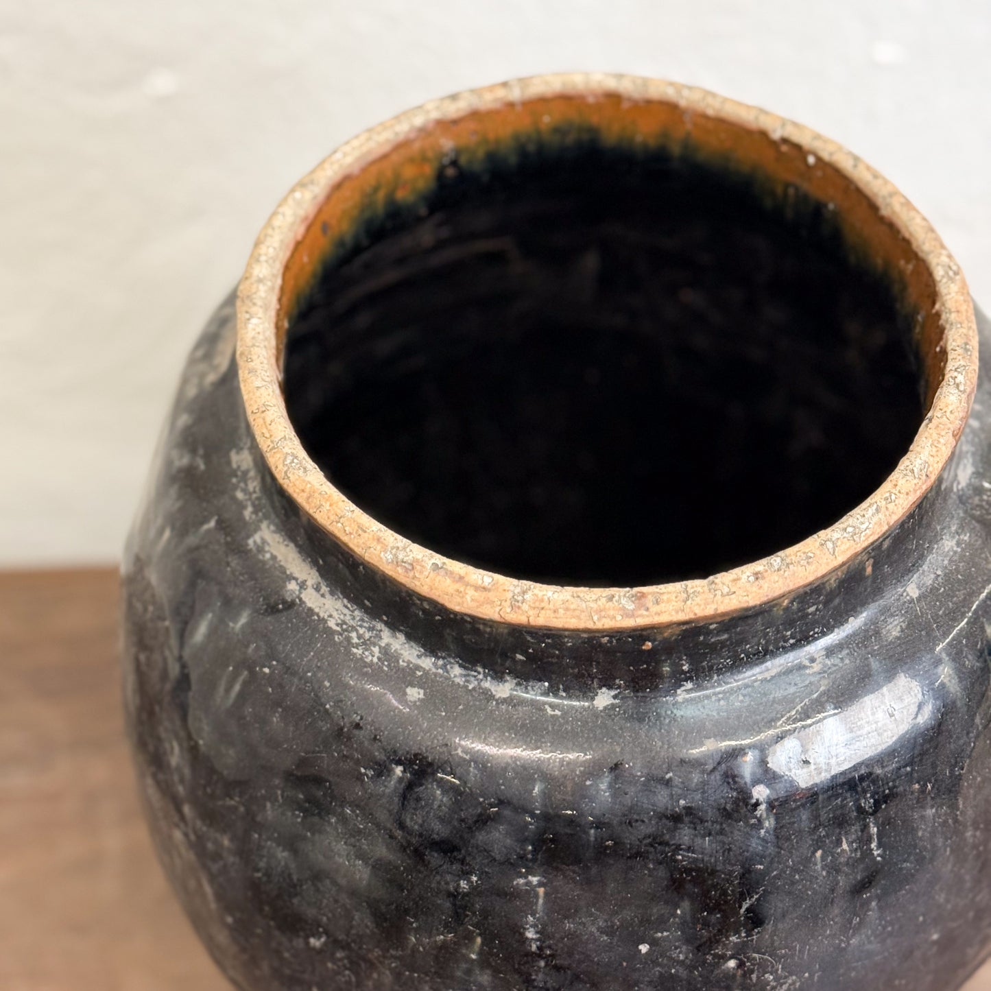 An Shanxi Style Glazed Storage Pot placed on a wooden floor against a white background.
