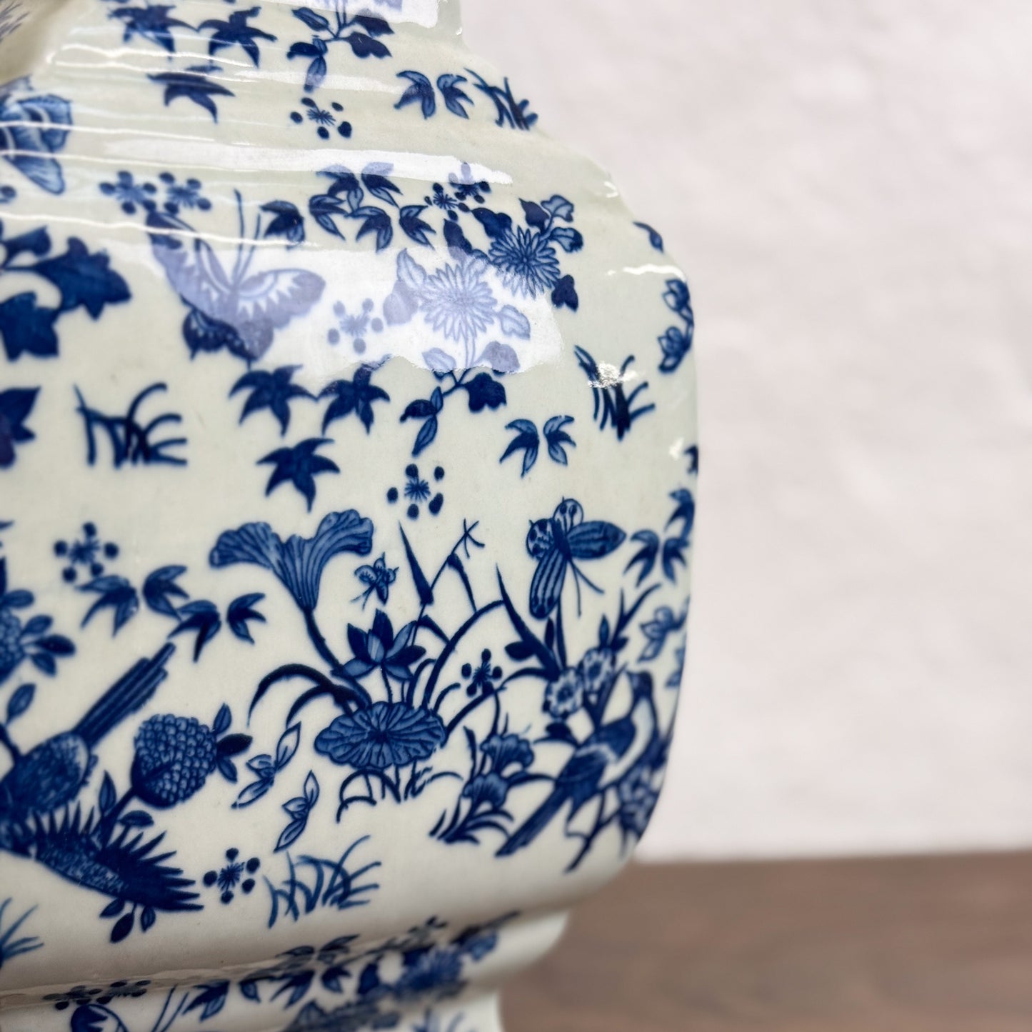A square-shaped porcelain vase with a floral pattern in blue and white colors, displayed against a white background