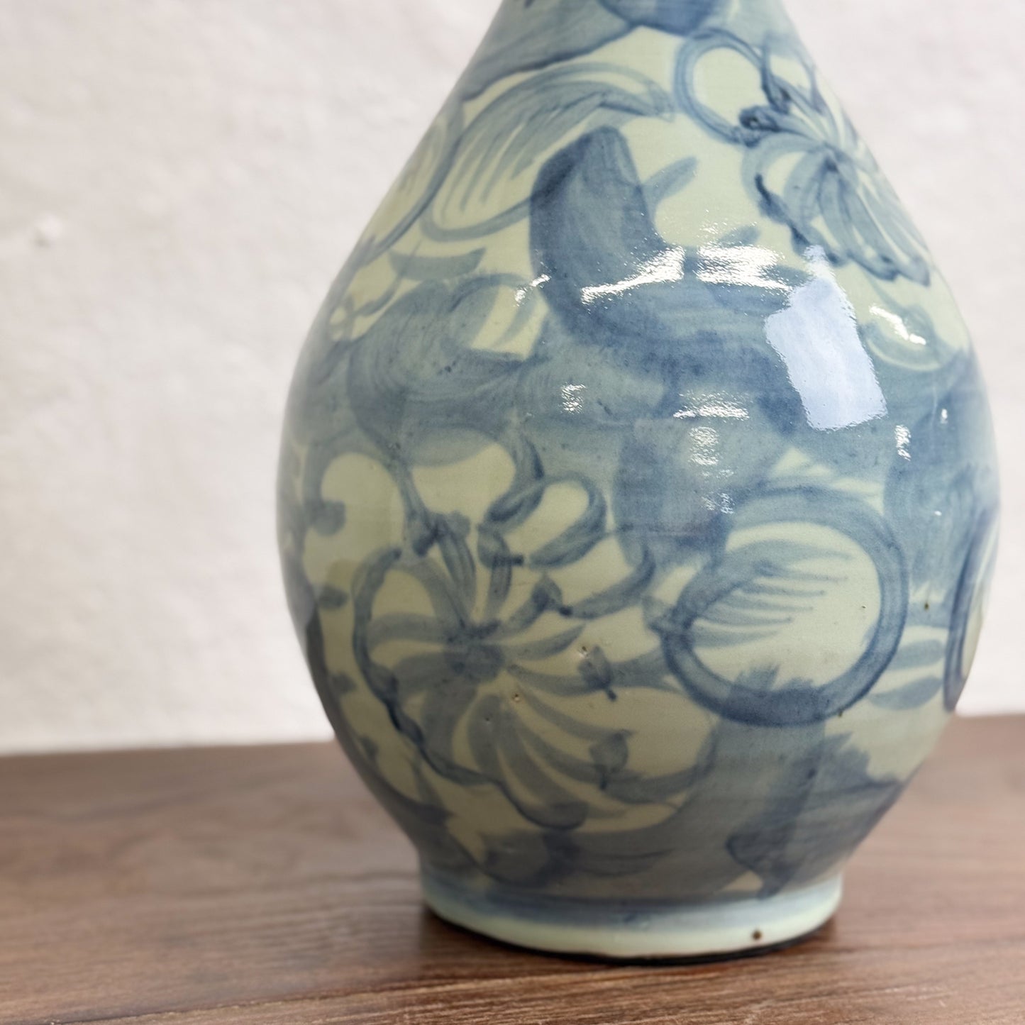 A blue and white porcelain vase with a floral pattern, displayed against a neutral background.