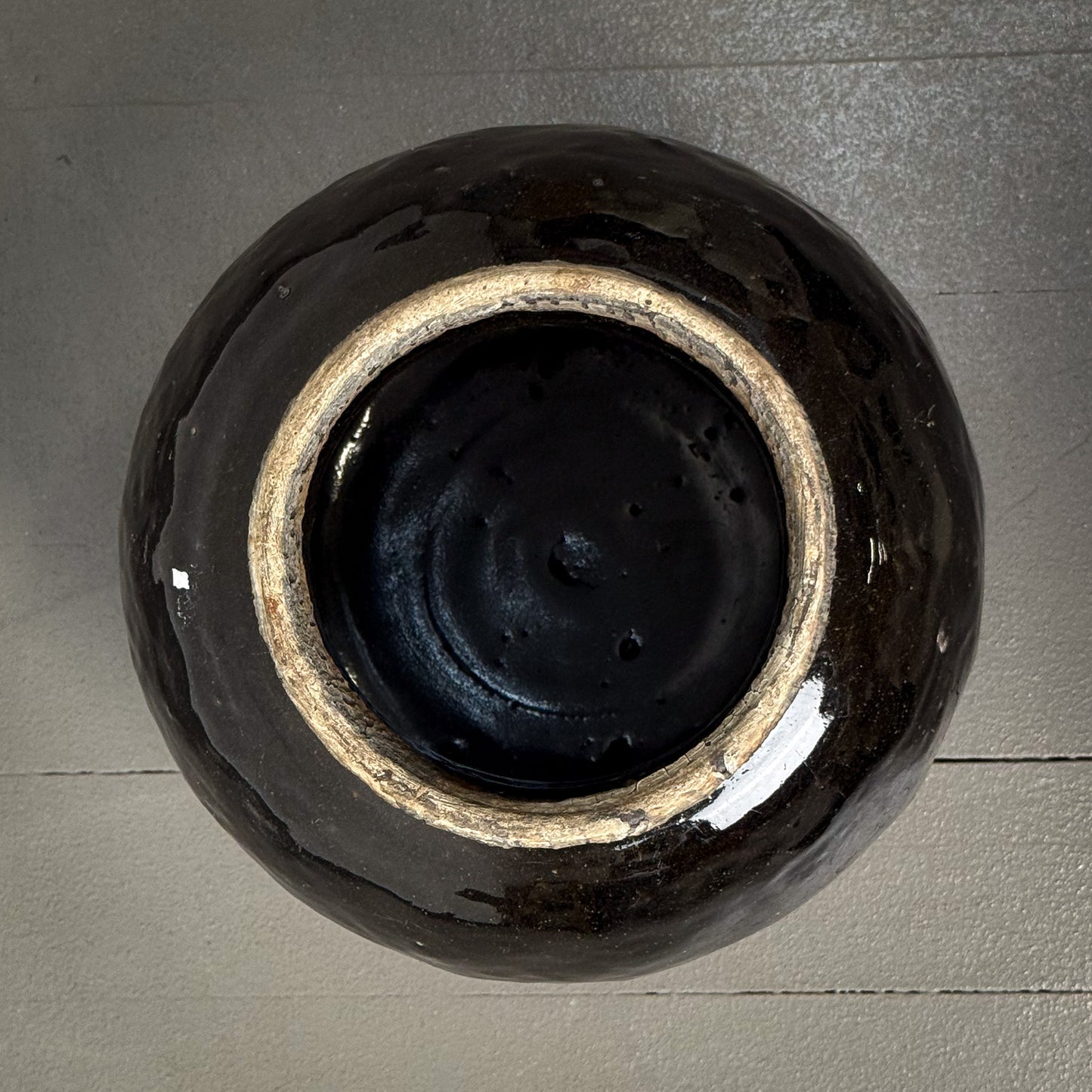 Black ceramic vase on a gray wooden surface