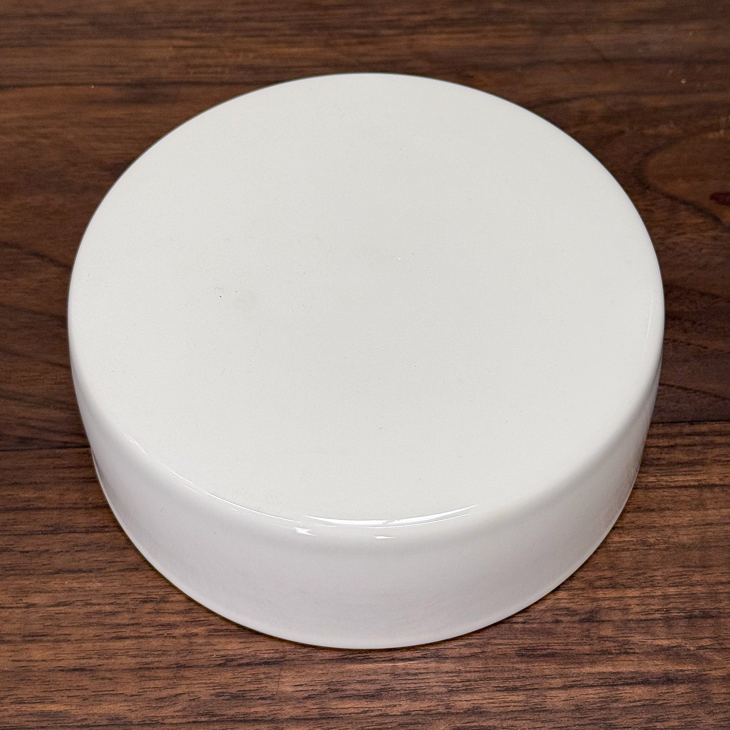 White cylindrical object on a wooden surface