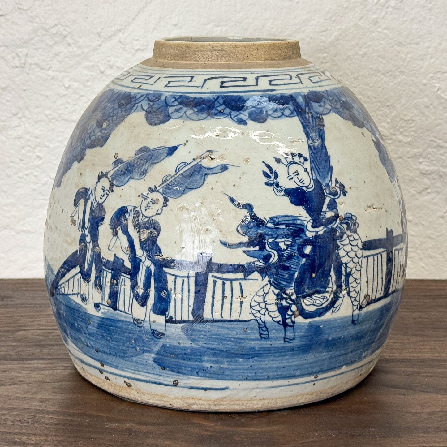Blue and white ceramic jar with decorative designs on a wooden surface