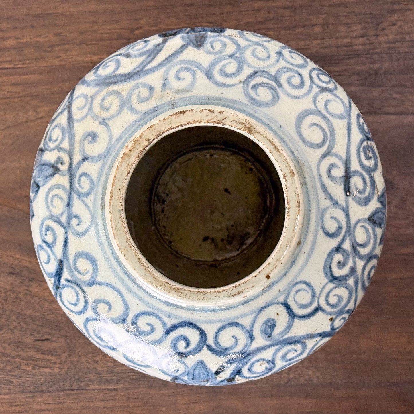 Ceramic jar with blue and white decorative patterns on a wooden surface