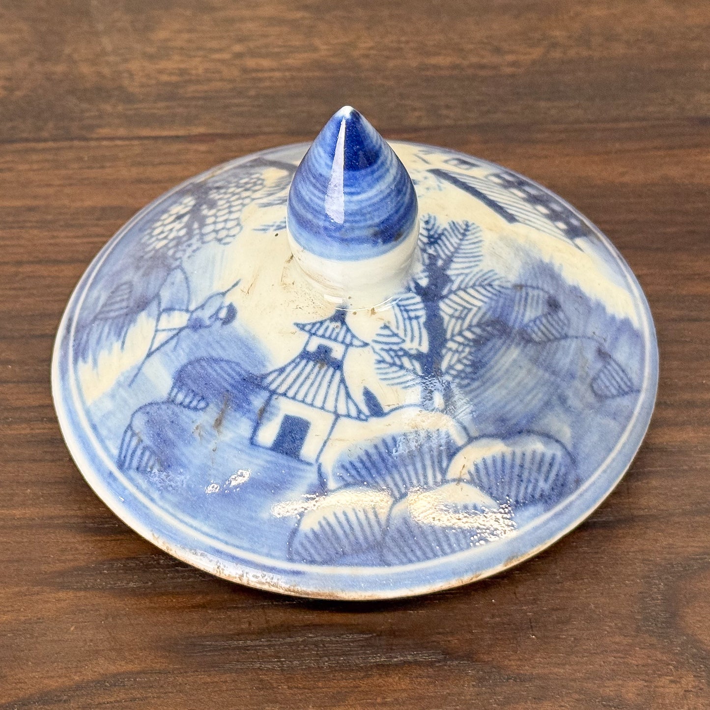 Blue and white ceramic incense burner with landscape design on a wooden surface