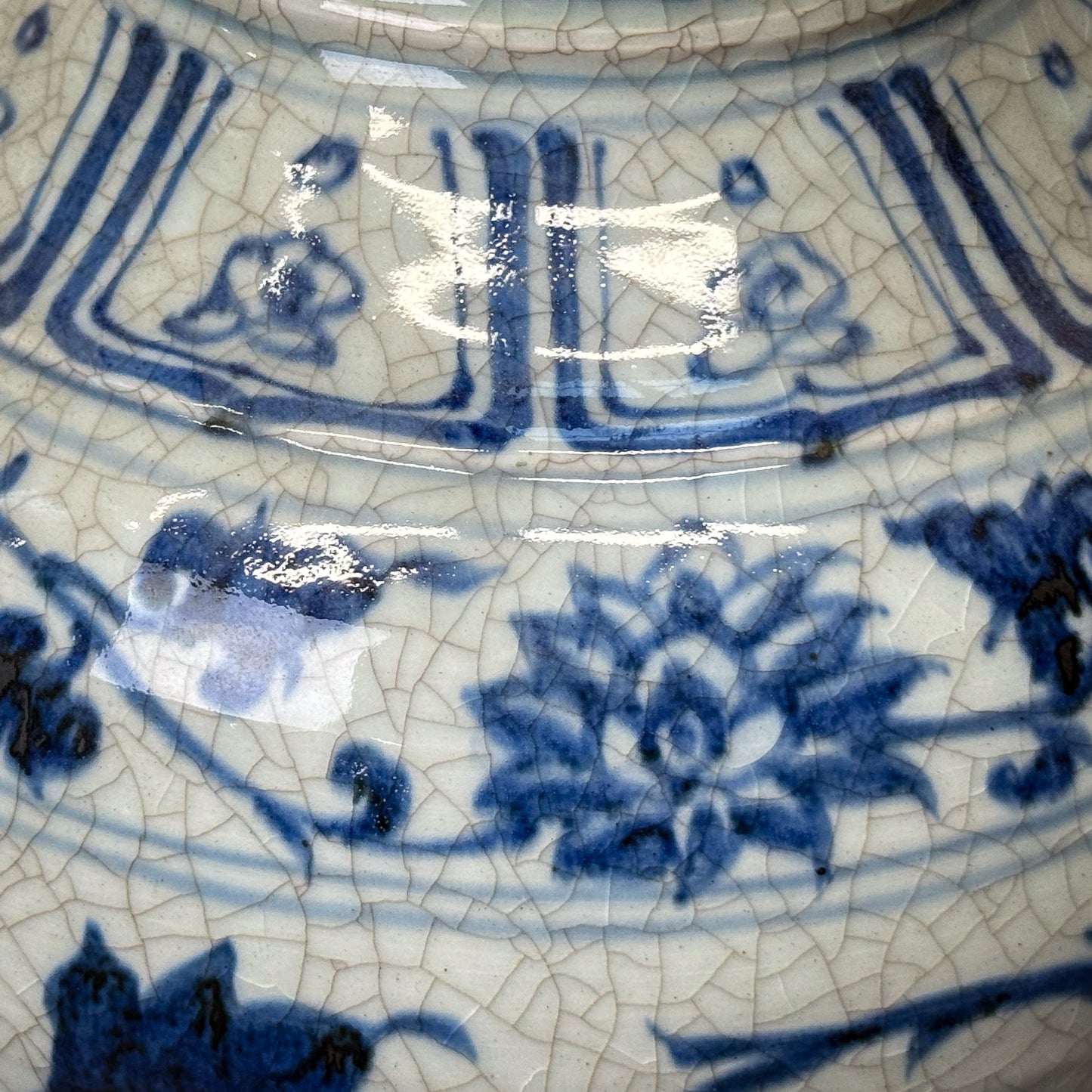 Close-up of a ceramic dish with blue floral patterns on a cracked surface