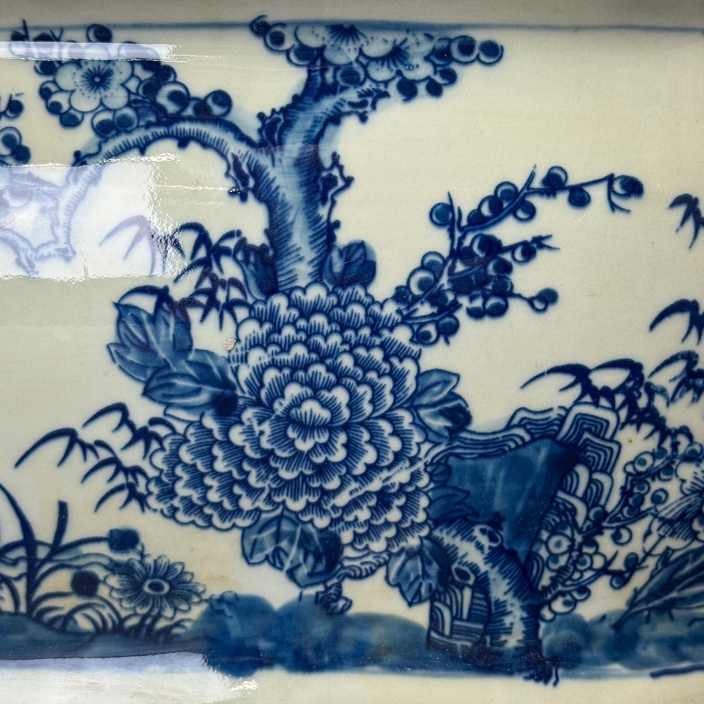 Close-up of blue floral and bird design on white ceramic tile
