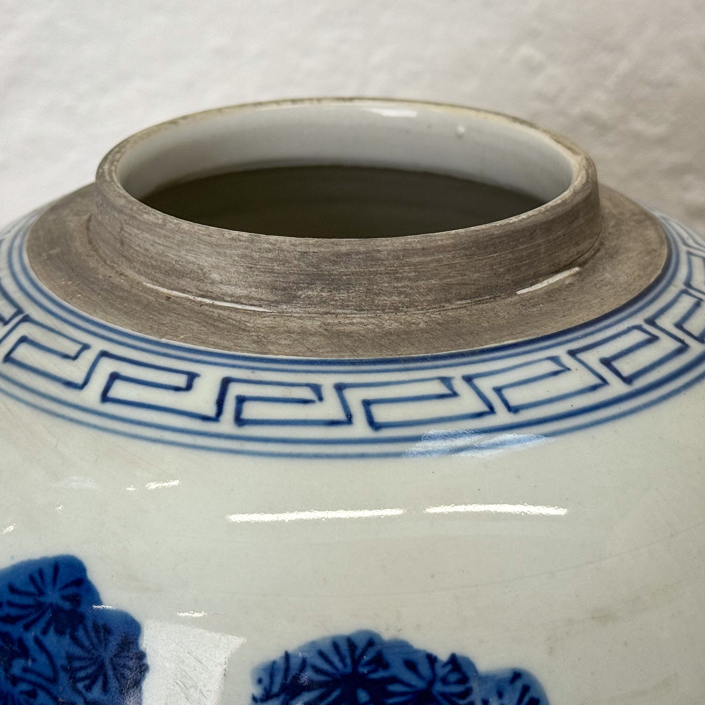 Close-up of a ceramic jar with blue floral patterns on a white background
