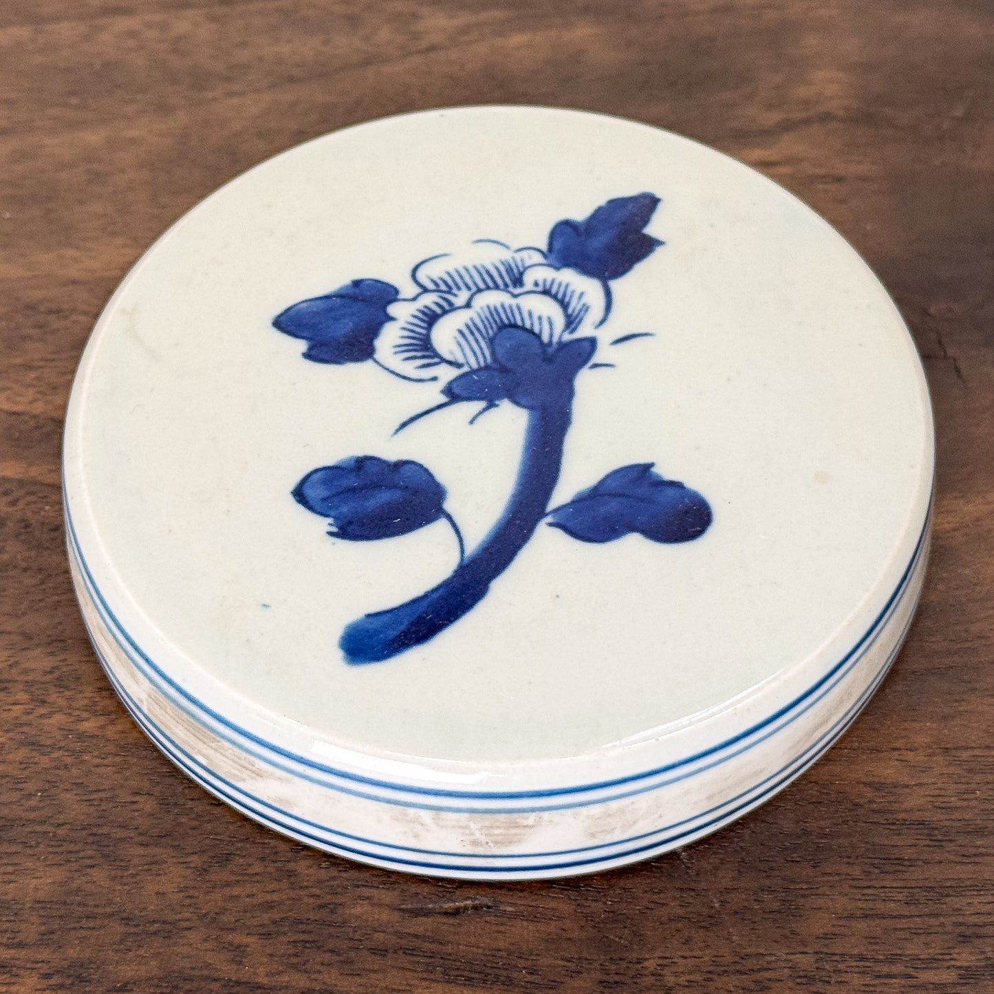 Round ceramic dish with blue floral design on a wooden surface