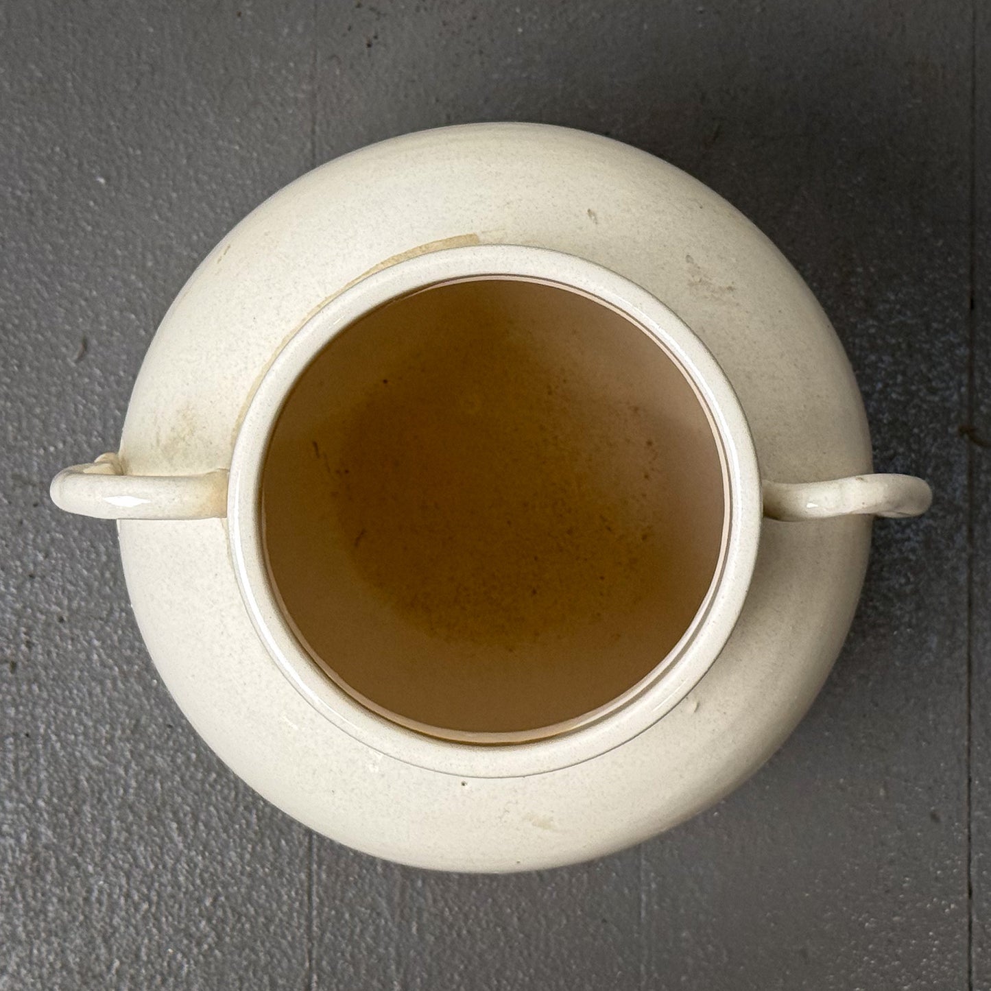 White ceramic pot with handles on a gray background