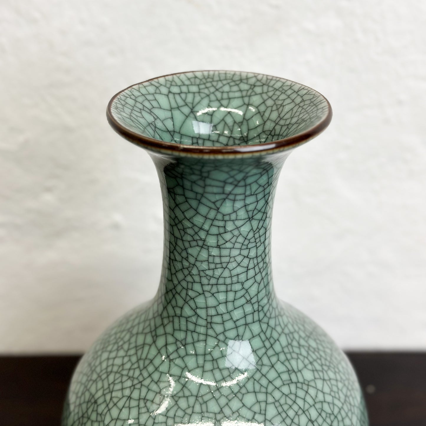 A crackled celadon globular vase with flared lip, displayed against a neutral background.